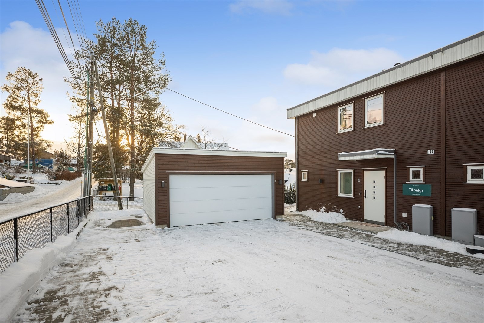 Hele gårdsplassen og inngangspartiet er pent belagt med belegningsstein som gir et ryddig inntrykk. Parkering i halvpart av dobbelgarasje samt på stor gårdsplass som deles med nabo i 14B. Elbil-lader montert. Galleribilde