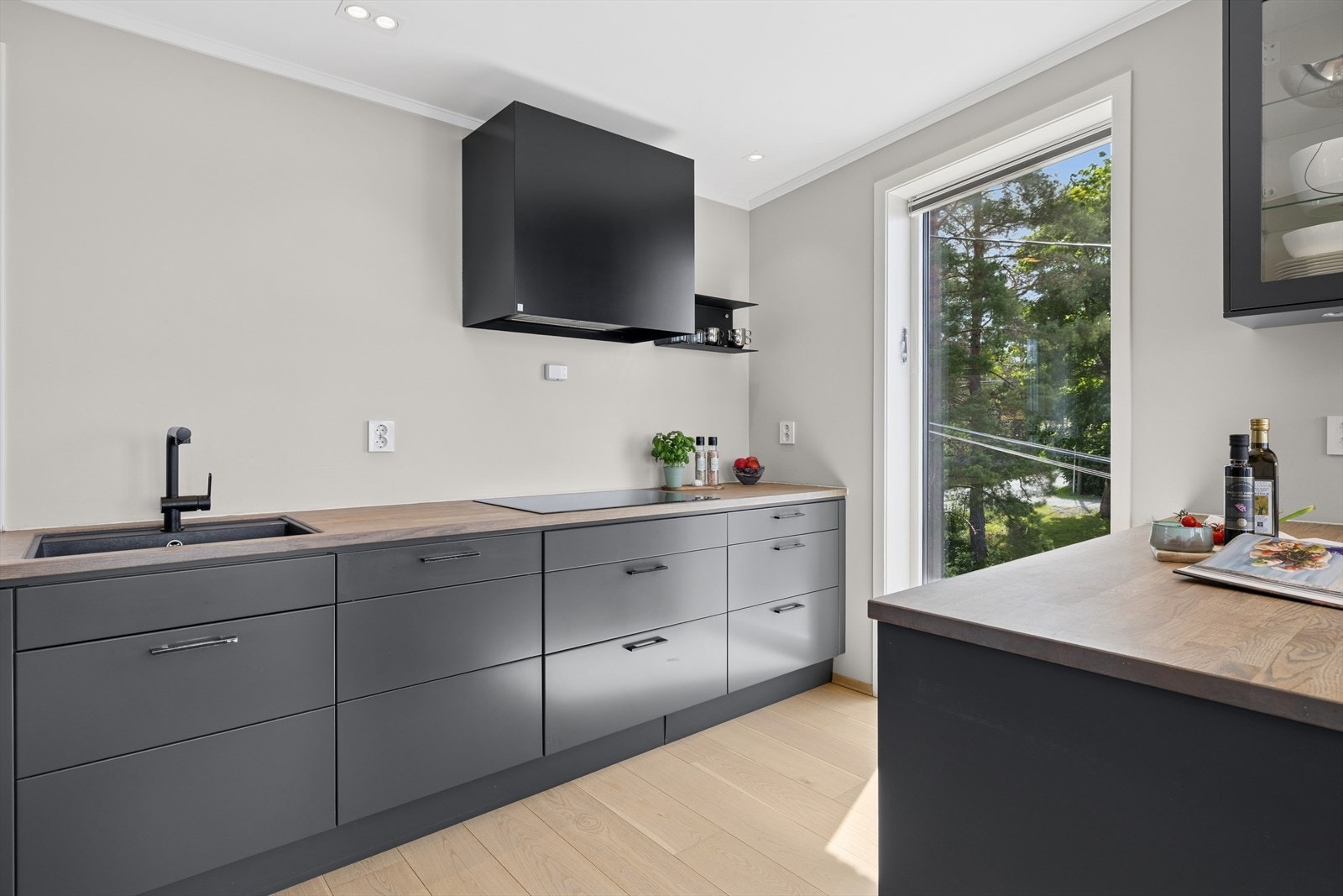 Innredning fra Drømmekjøkkenet med glatte fronter og benkeplate av tre. Galleribilde