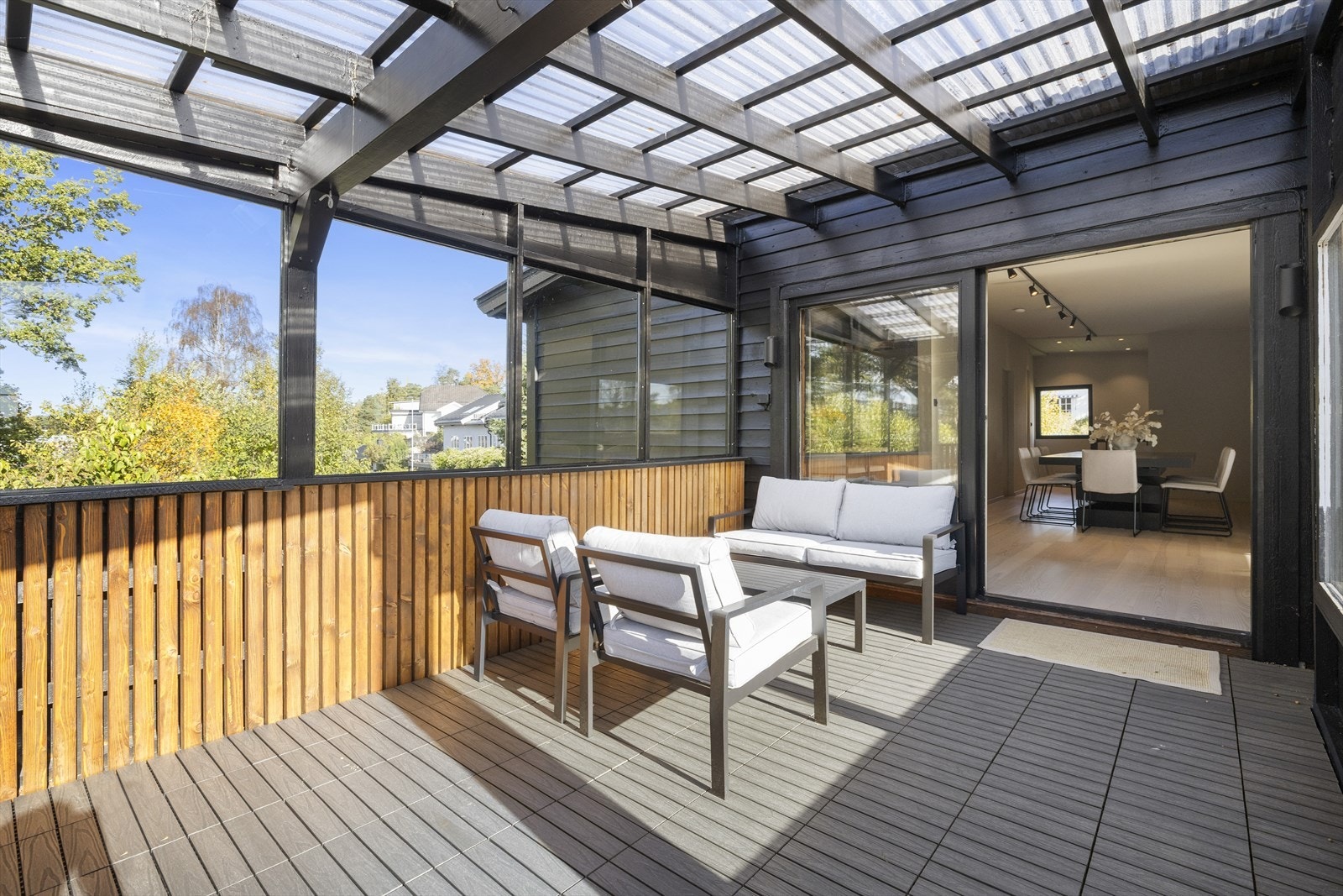 Terrassen har spaltegulv av impregnerte terrassebord som er oljet/beiset, og deler av gulvet er belagt med terrassefliser i plast Galleribilde