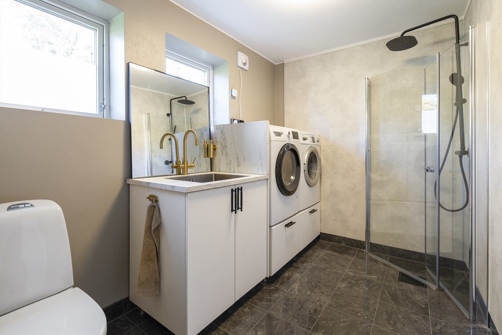 Badet i første etasje har adkomst fra gangen, og fungerer også som vaskerom. Rommet ble renovert i 2023 Galleribilde