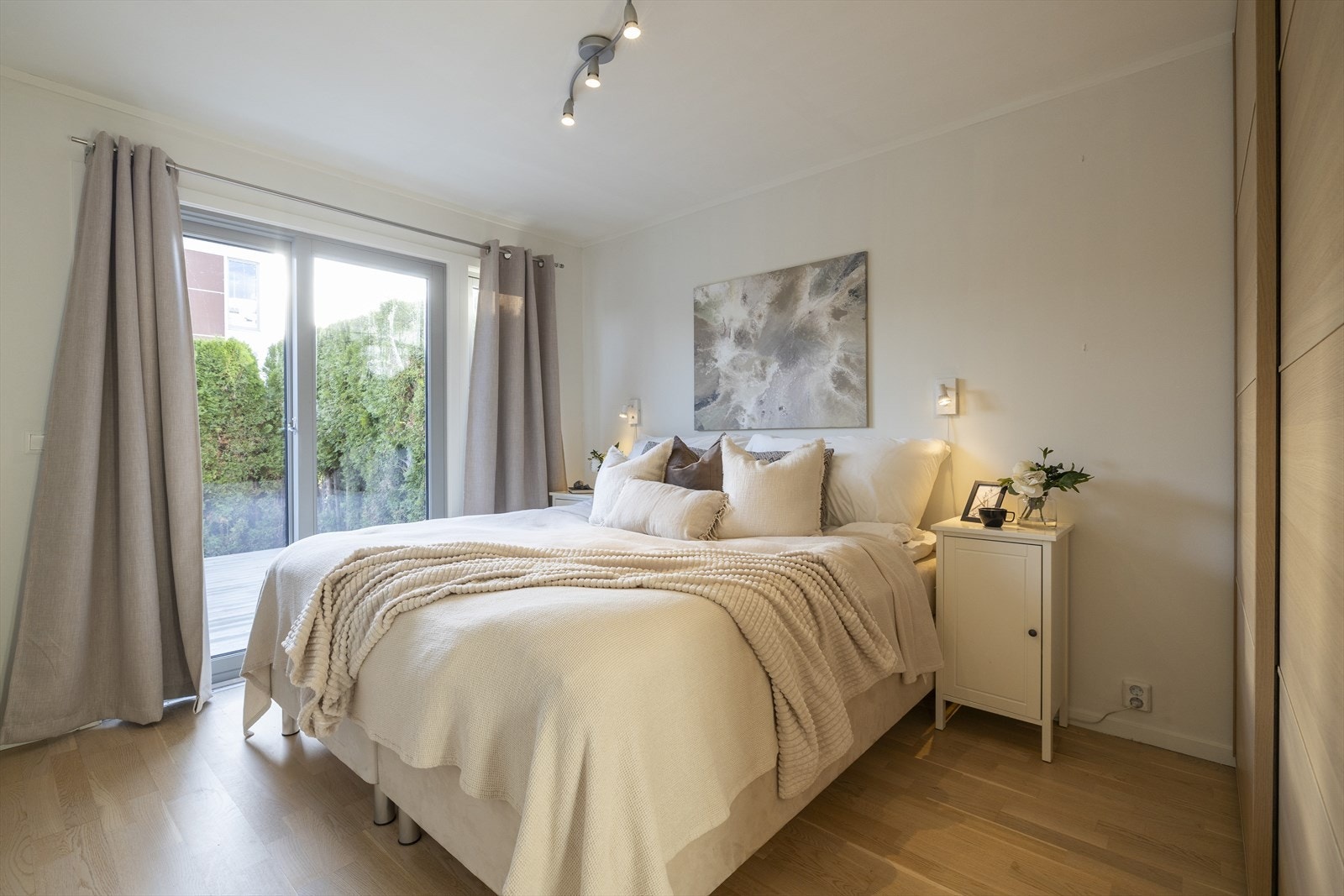 Soverom 1 med heldekkende skyvedørsgarderobe. Utgang fra soverom til skjermet terrasseplatting og hage Galleribilde