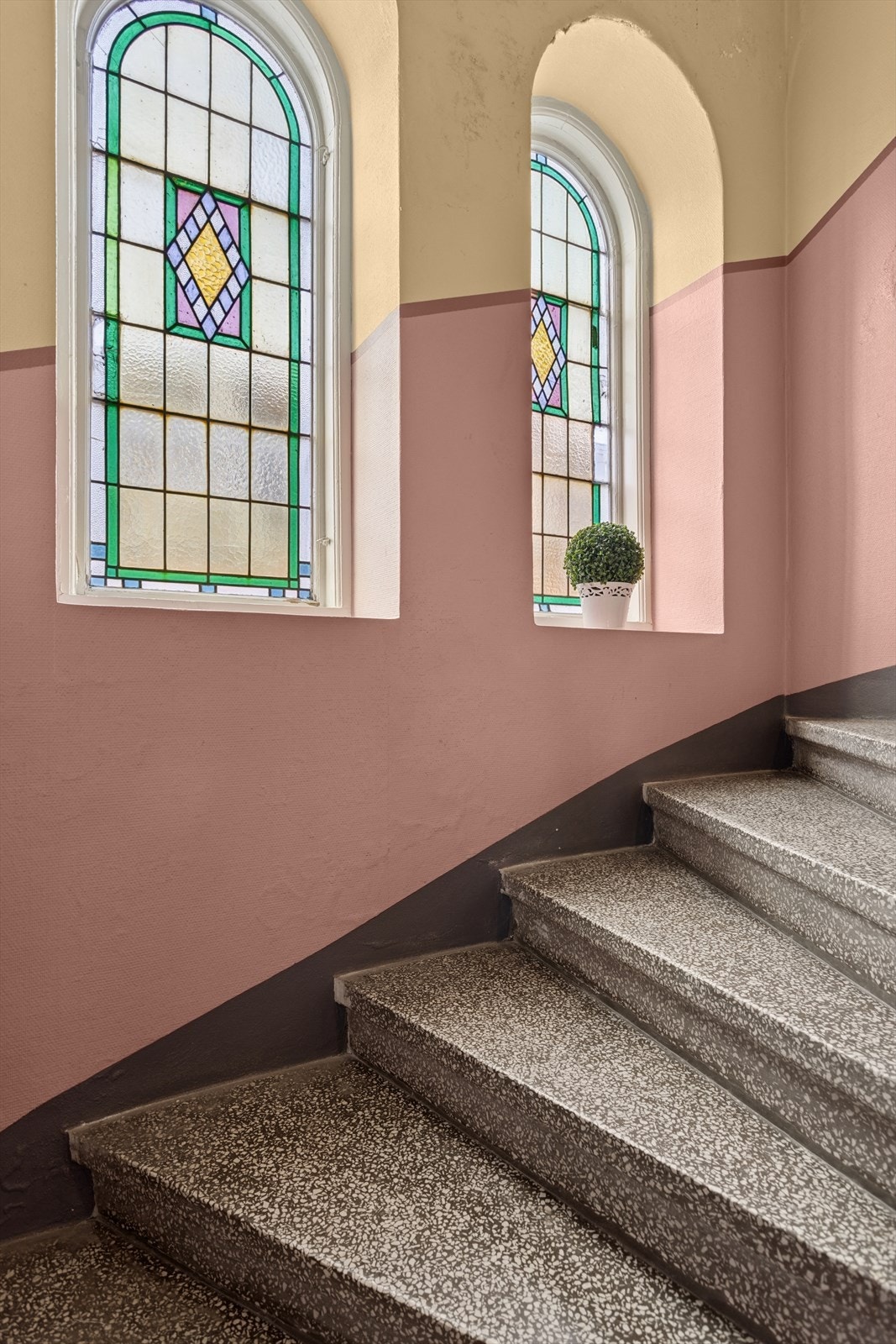Vinduer med farget glass tilfører trappeoppgangen et dekorativt element. Galleribilde
