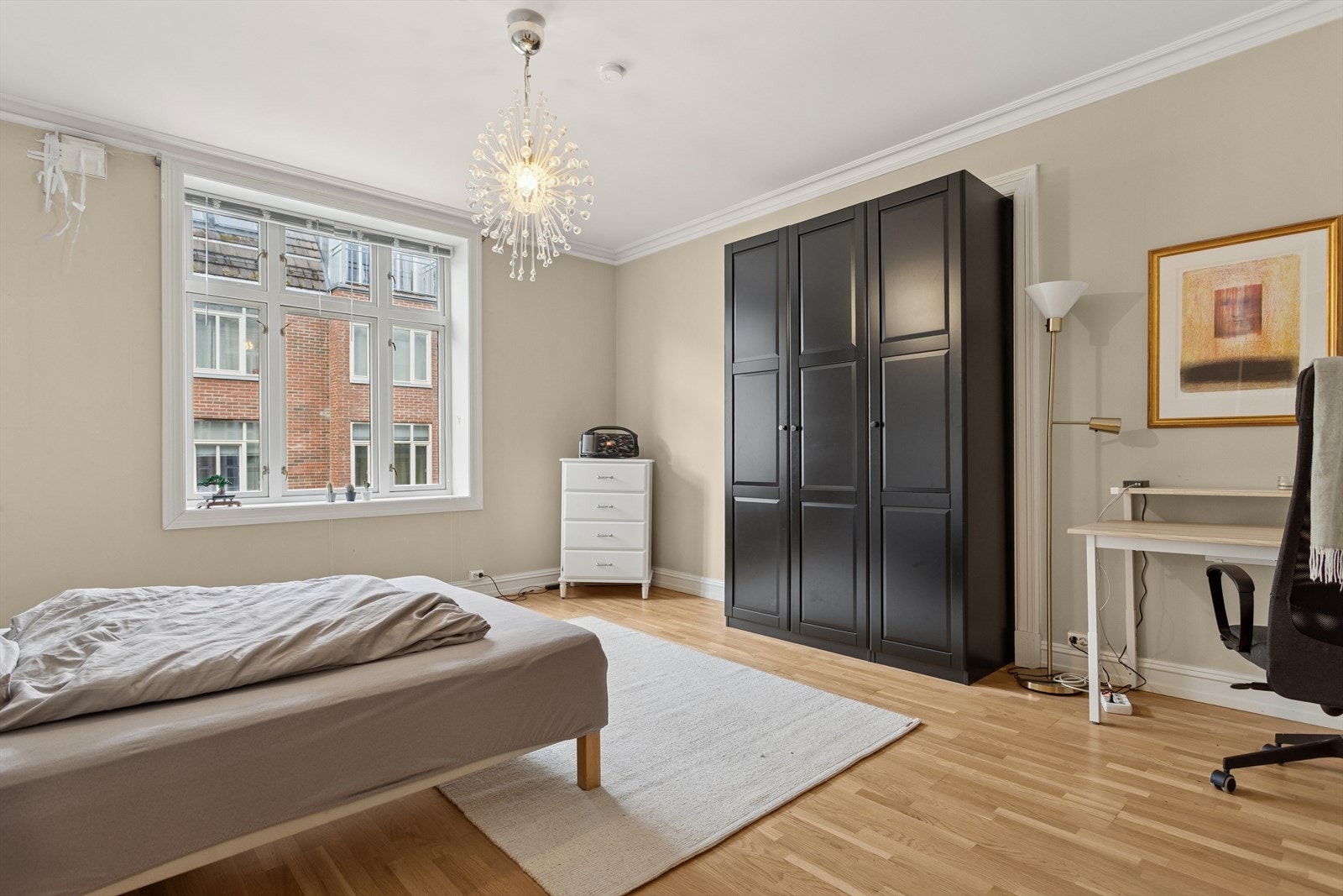 Skyvedørsgarderobe gir effektiv oppbevaring i rommet. Bak skapet skimtes dobbeltdøren som knytter de to stuene sammen. Galleribilde