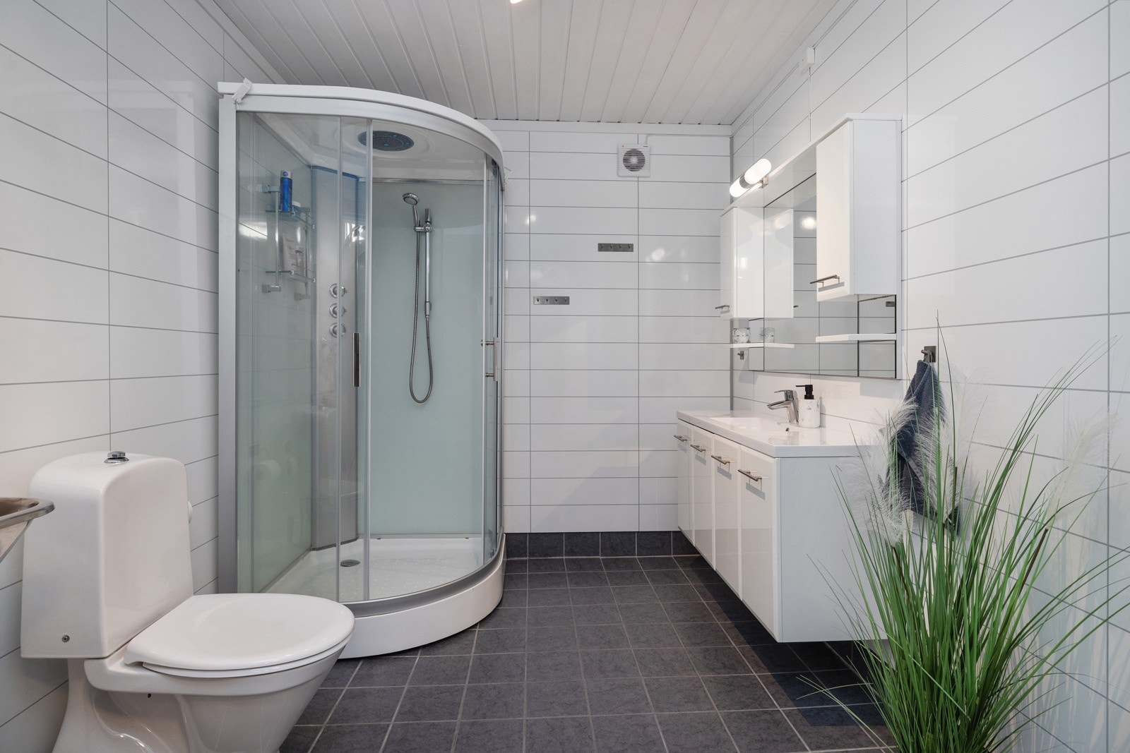 Bad renovert i 2021, med baderomsplater på vegg og fliser med varmekabler i gulv. Galleribilde