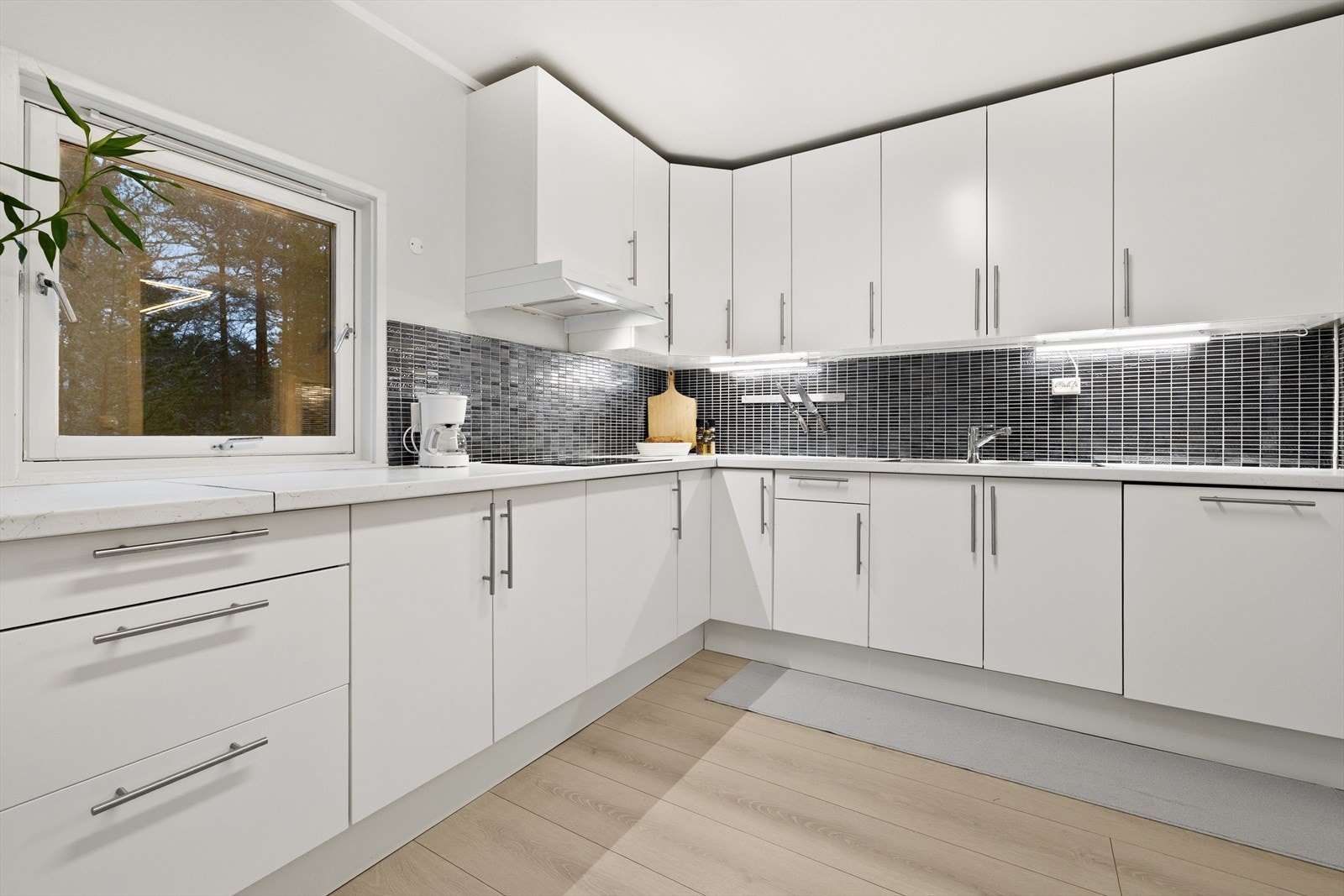 Kjøkken med slette fronter, som ble byttet ut i 2025. Galleribilde