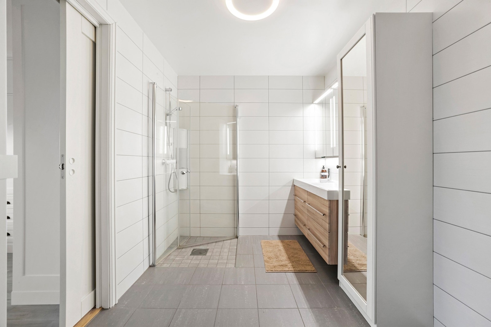 Flislagt bad med varmekabler og senket dusjnisje. Det er skyvedør fra hovedsoverommet inn på badet Galleribilde