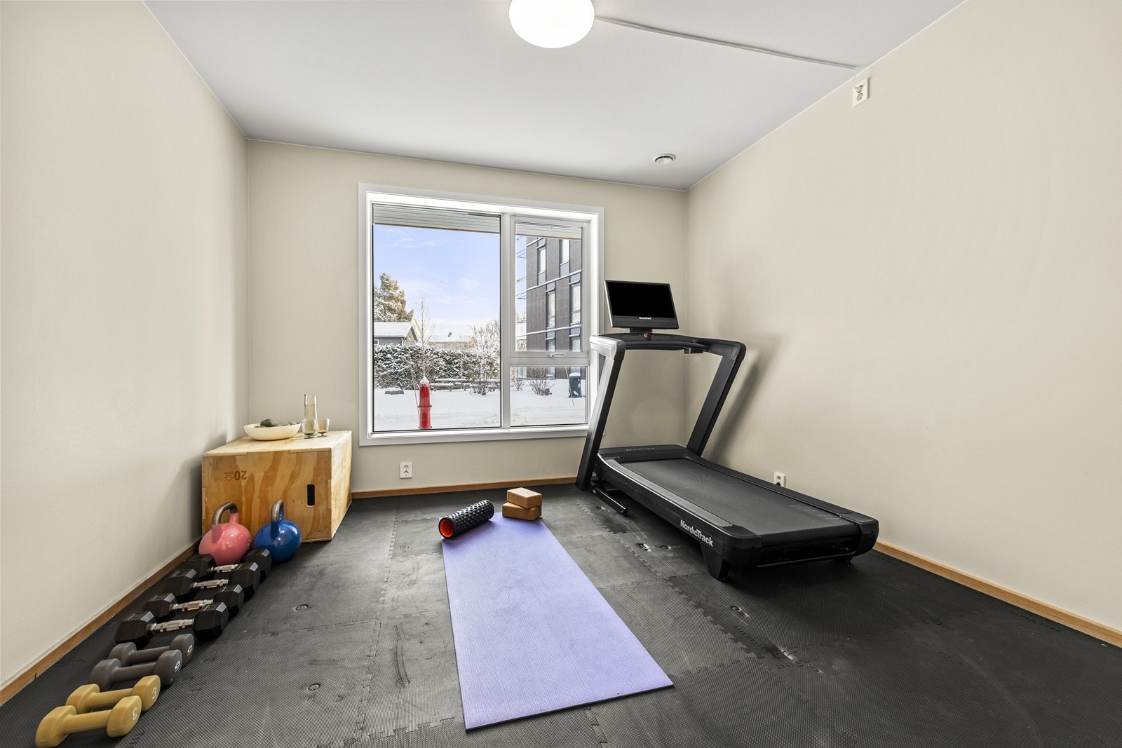 Lyst og romslig soverom med store vinduer som gir rikelig med dagslys, for tiden innredet som treningsrom. Galleribilde