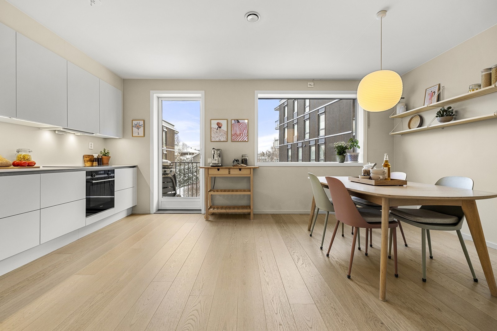 Kjøkken med delvis åpen løsning mot stue og med utgang til balkong. Galleribilde