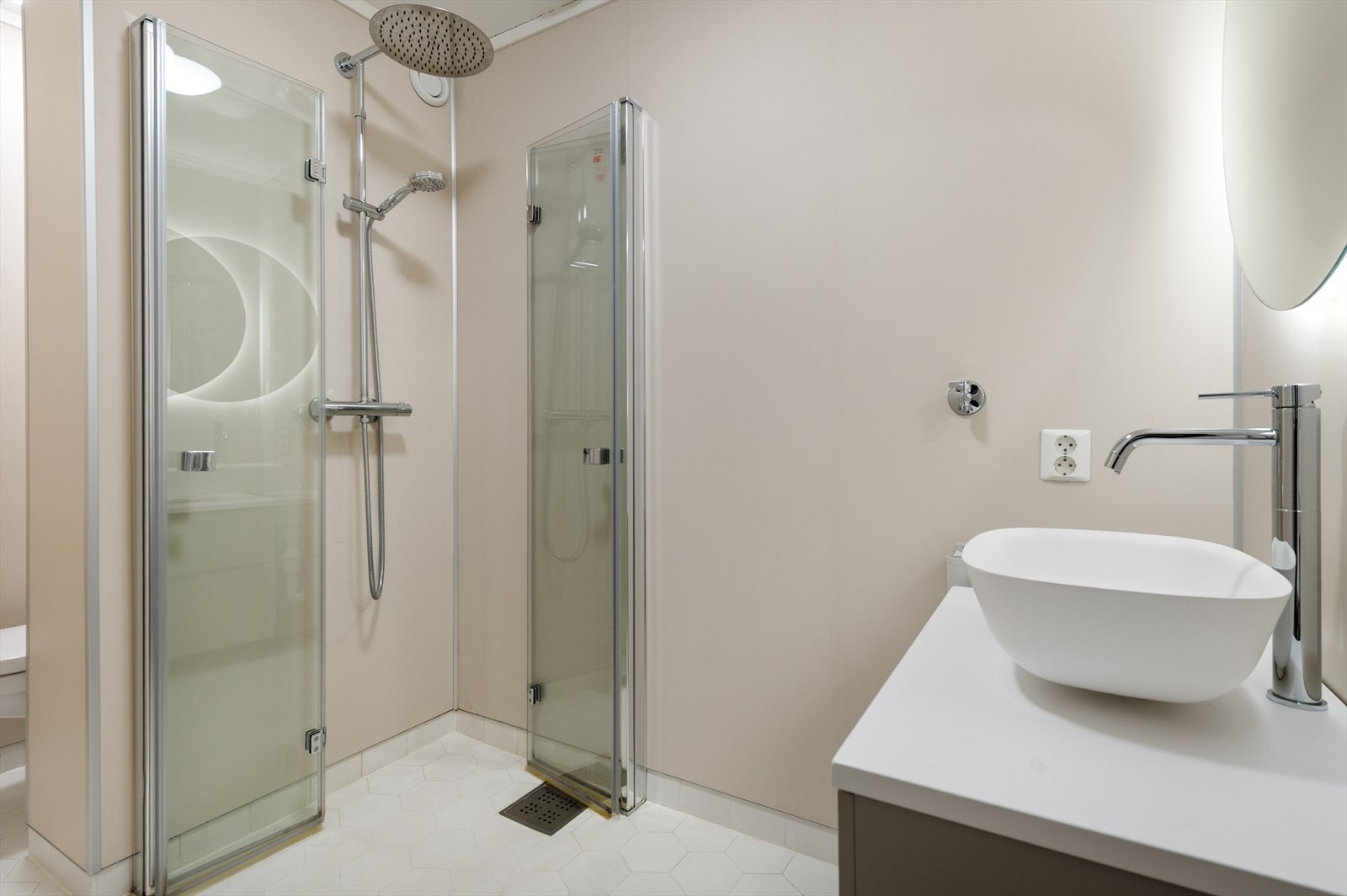 Nyere baderom med opplegg for vaskemaskin, vegghengt toalett og dusj med innfellbare dusjvegger. Galleribilde