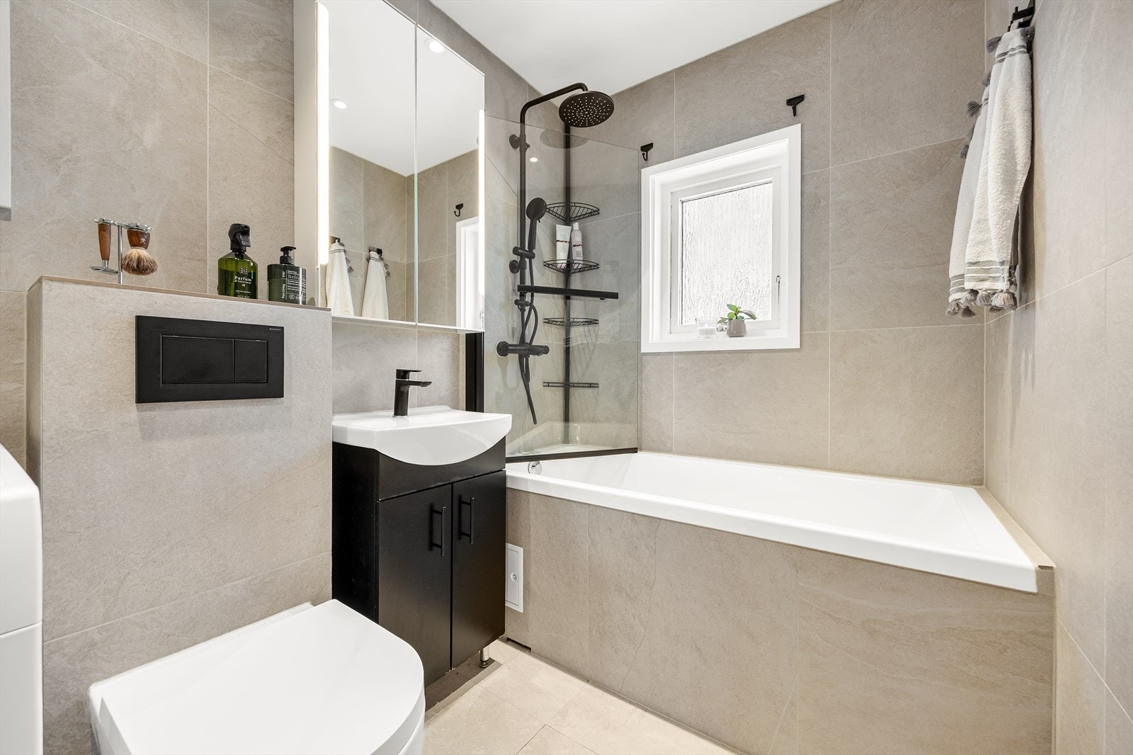 Badet som ble pusset opp i 2023 er helfliset med moderne, store fliser og har varme i gulvet. Galleribilde