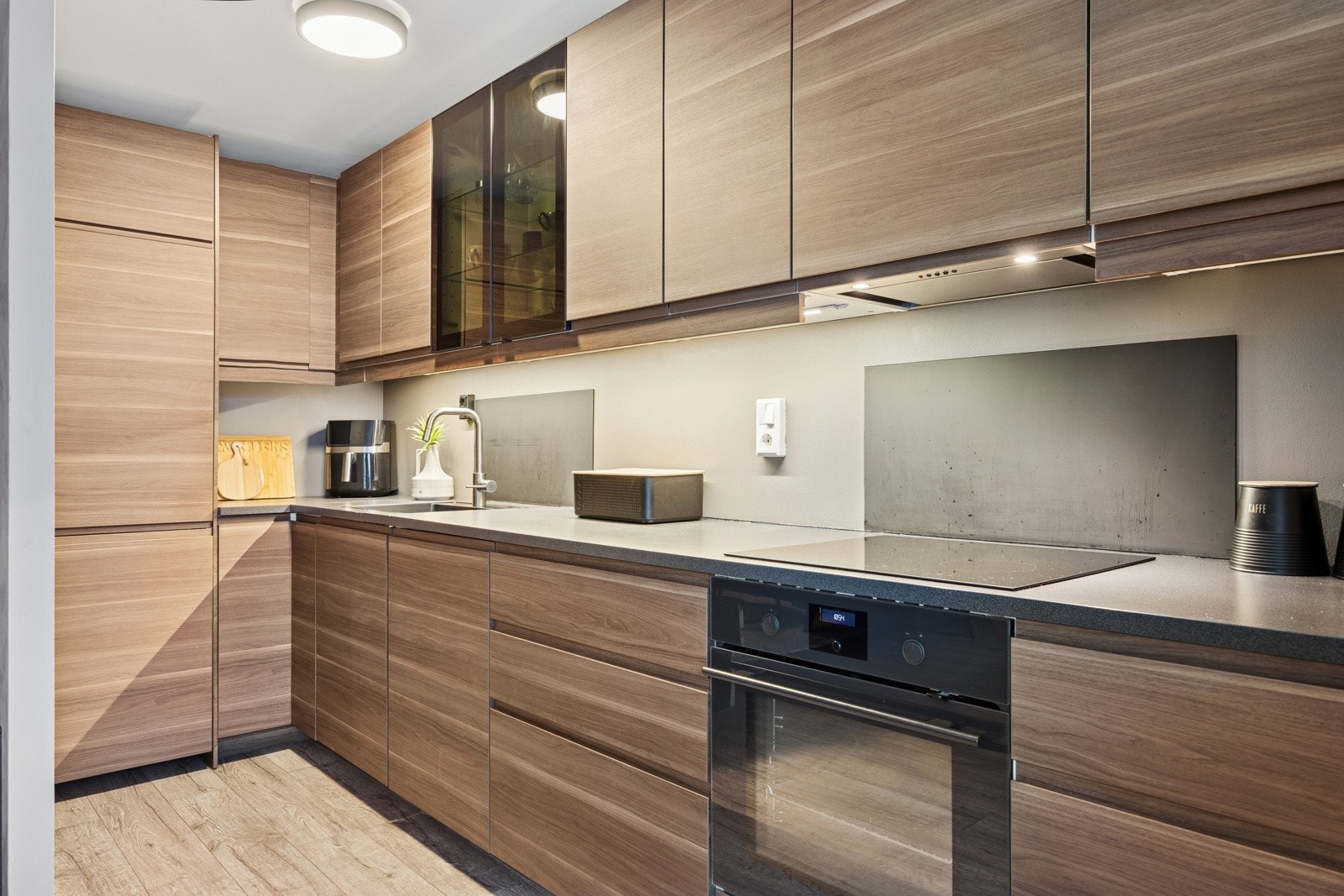 Det er rikelig med oppbevaringsplass i over- og underskap. Videre er det utstyrt med integrerte hvitevarer som stekeovn, platetopp, oppvaskmaskin og kjøl- og fryseskap. Galleribilde