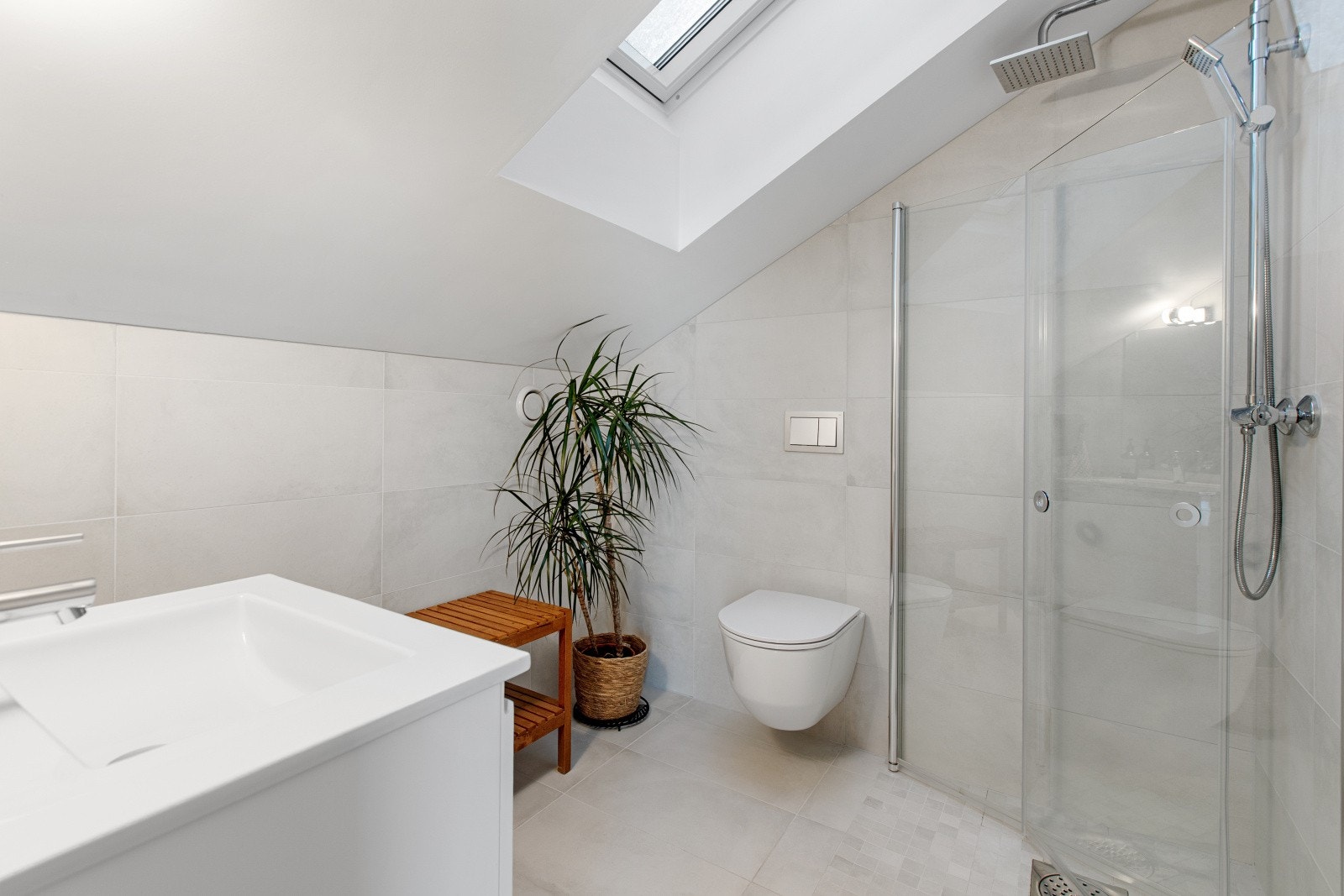 I toppetasjen finner du også et nydelig, flislagt baderom. Takvinduet slipper inn rikelig med naturlig lys og gir rommet en ekstra følelse av luksus. Galleribilde