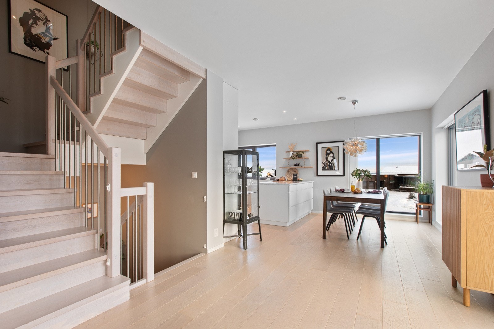 En flott tretrapp leder oss opp til andre etasje, hvor vi møtes av et romslig og lyst kjøkken- og stueområde med en åpen og innbydende atmosfære. Galleribilde