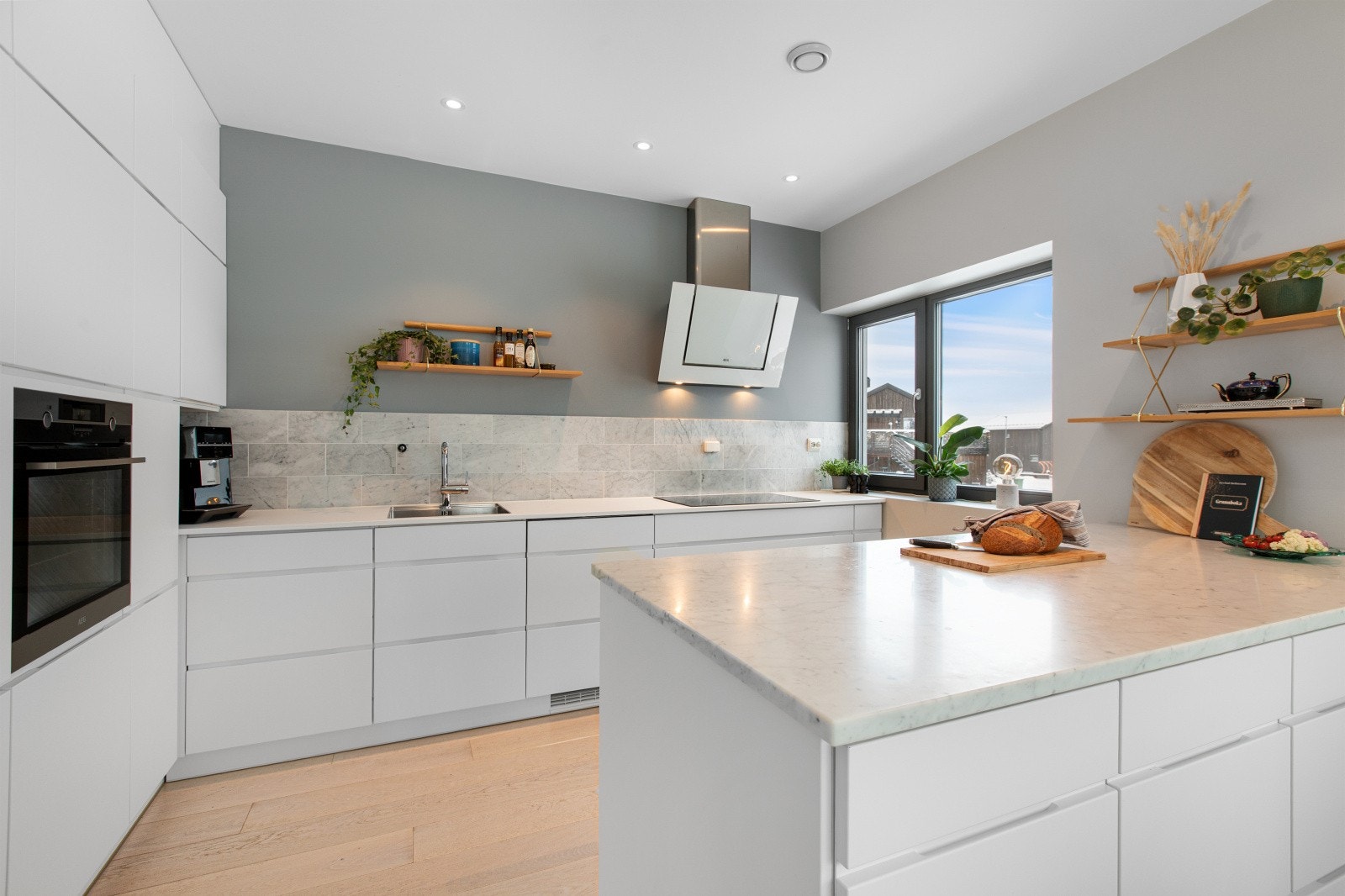 Delikat kjøkkeninnredning fra Kvik. Eier har påkostet kjøkkenet med eksklusiv marmor benkeplate, som også er videreført opp på veggen over benken for et helhetlig og stilrent uttrykk. Galleribilde