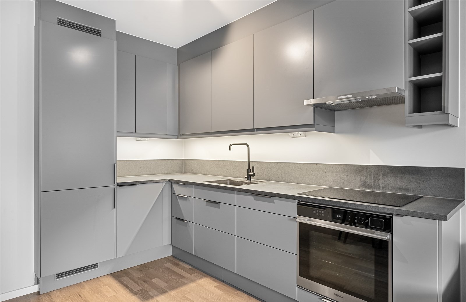 Integrerte hvitevarer inkluderer platetopp, komfyr, oppvaskmaskin og kjøl/frys, som gir et helhetlig og stilrent uttrykk. Galleribilde