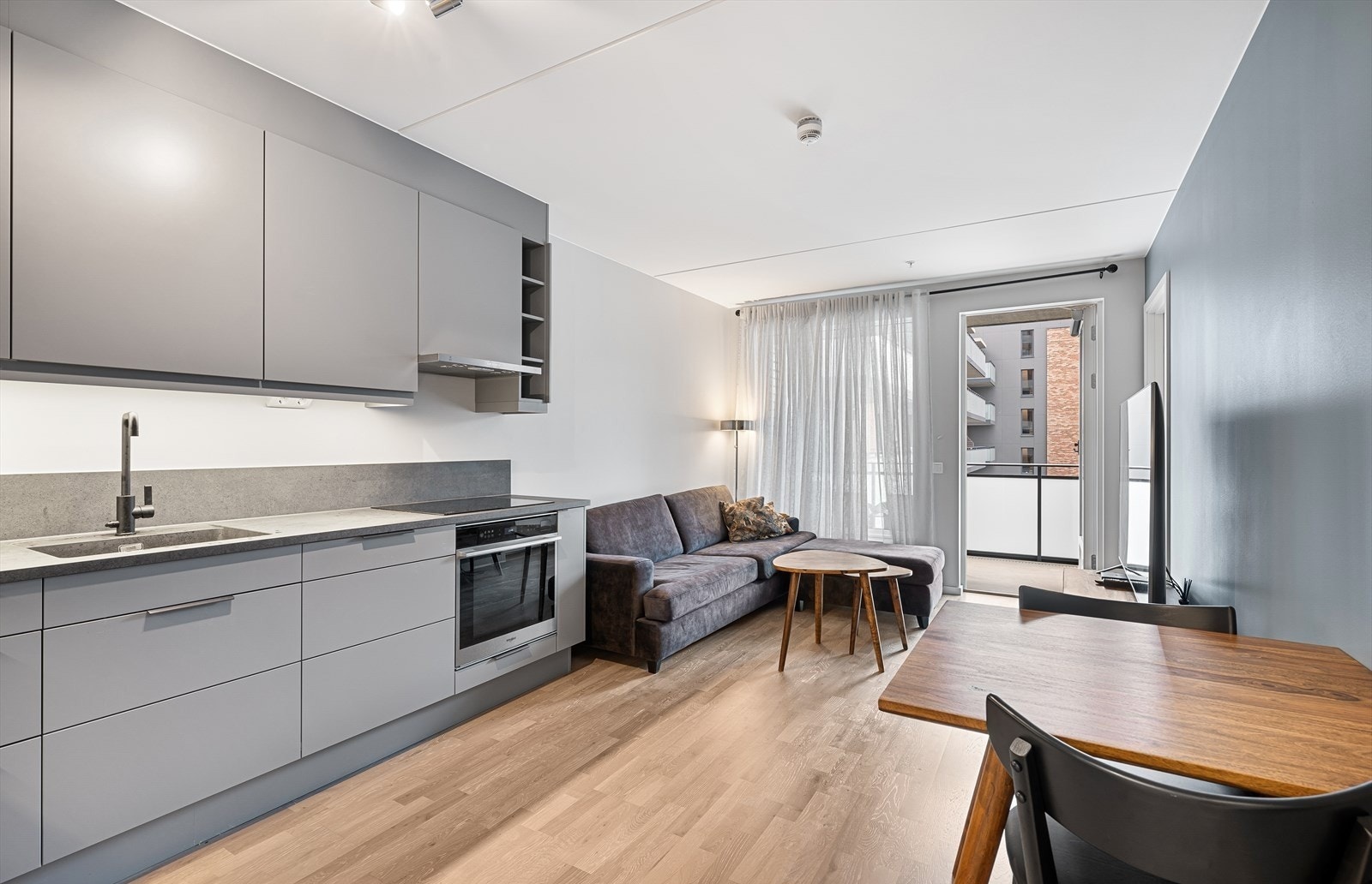 Den åpne planløsningen mellom stue og kjøkken gjør det enkelt å samle venner og familie, samtidig som den skaper en naturlig flyt i hverdagen. Galleribilde