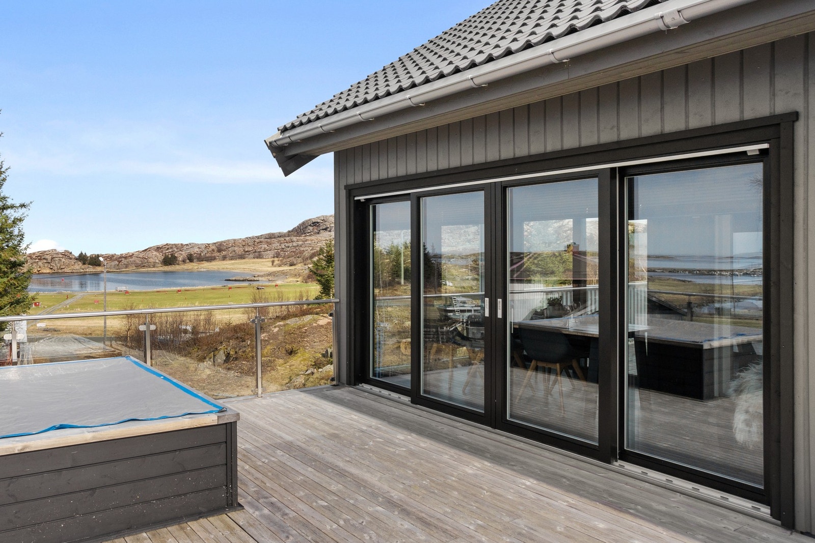 Heveskyvedør som fører ut til en romslig terrasse fra stuen. Galleribilde