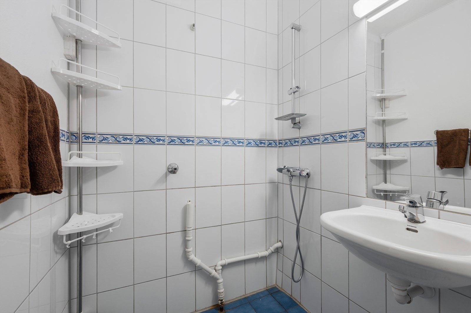 Badet er på 2m² og er utstyrt gulvvarme, med mekanisk avtrekk, opplegg for vaskemaskin, servant og åpen dusj. Galleribilde