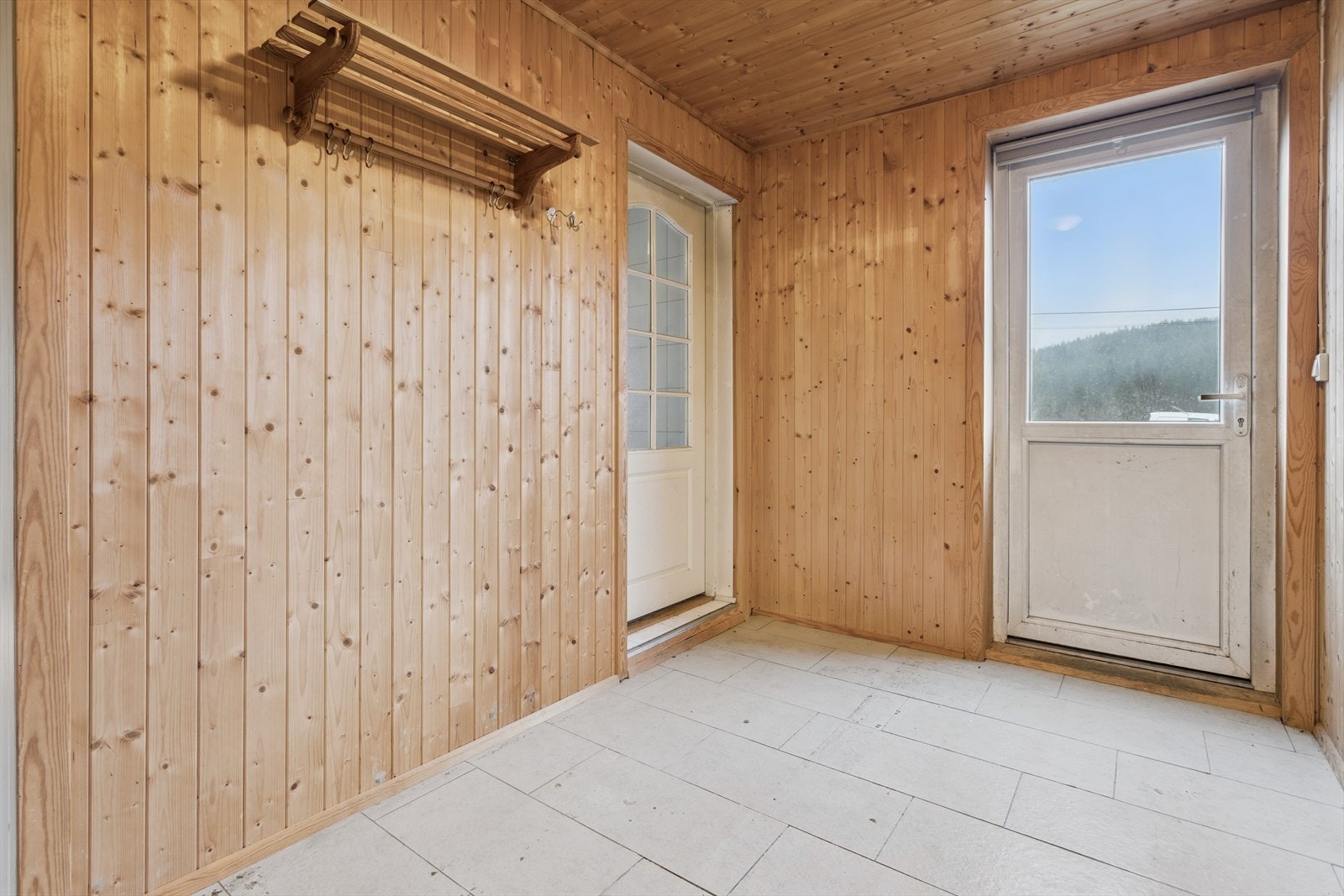 Inngangspartiet har flislagt gulv og gir adkomst videre inn i boligen. Galleribilde