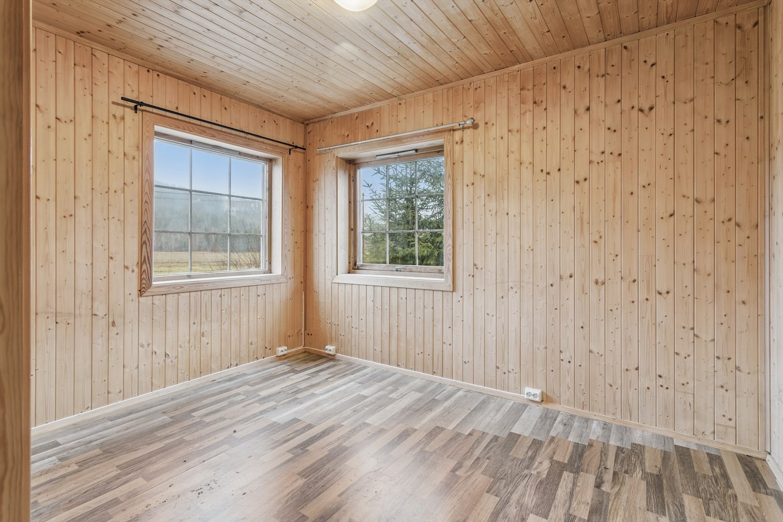 Dette soverommet har panel på vegger og tak, og laminat på gulvet. Galleribilde