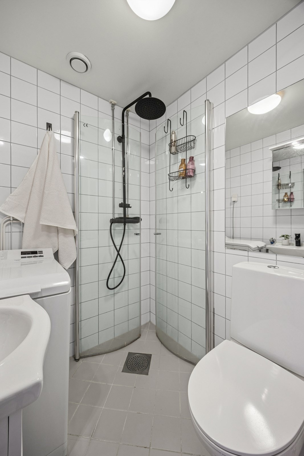 Praktisk baderom med servant, speil med belysning og skap med glatte fronter Galleribilde