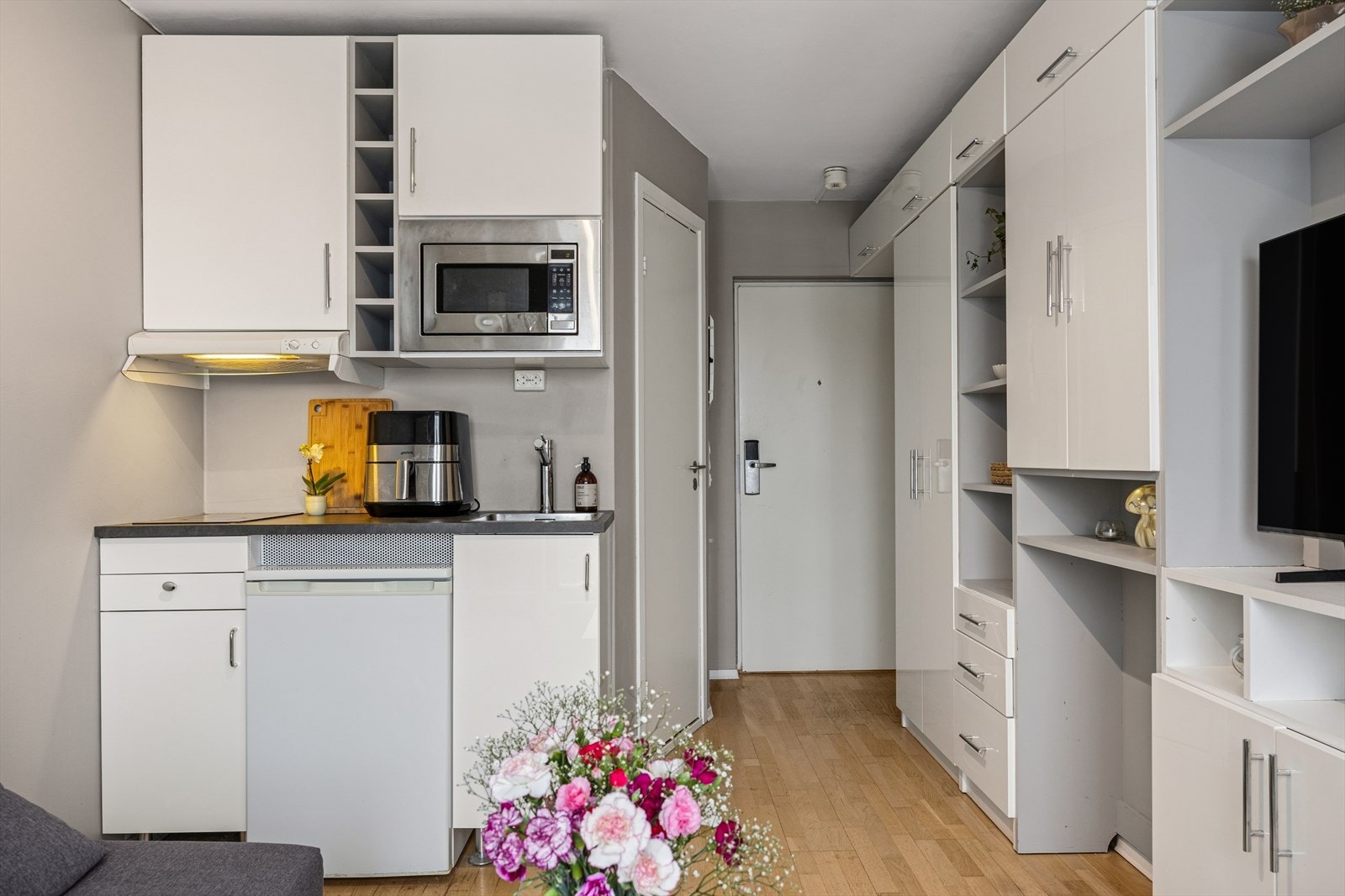 Funksjonelt kjøkken med glatte fronter, integrerte hvitevarer og arbeidsflate Galleribilde