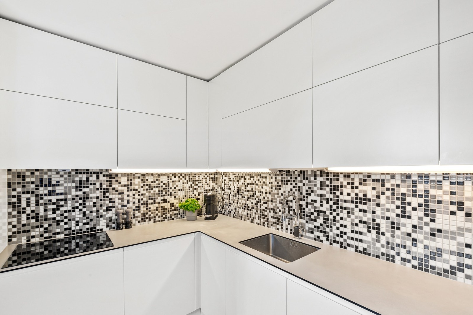 Kjøkkenet byr på god skap- og oppbevaringsplass, samt en praktisk og romslig arbeidsflate som gjør matlagingen både effektiv og oversiktlig. Galleribilde