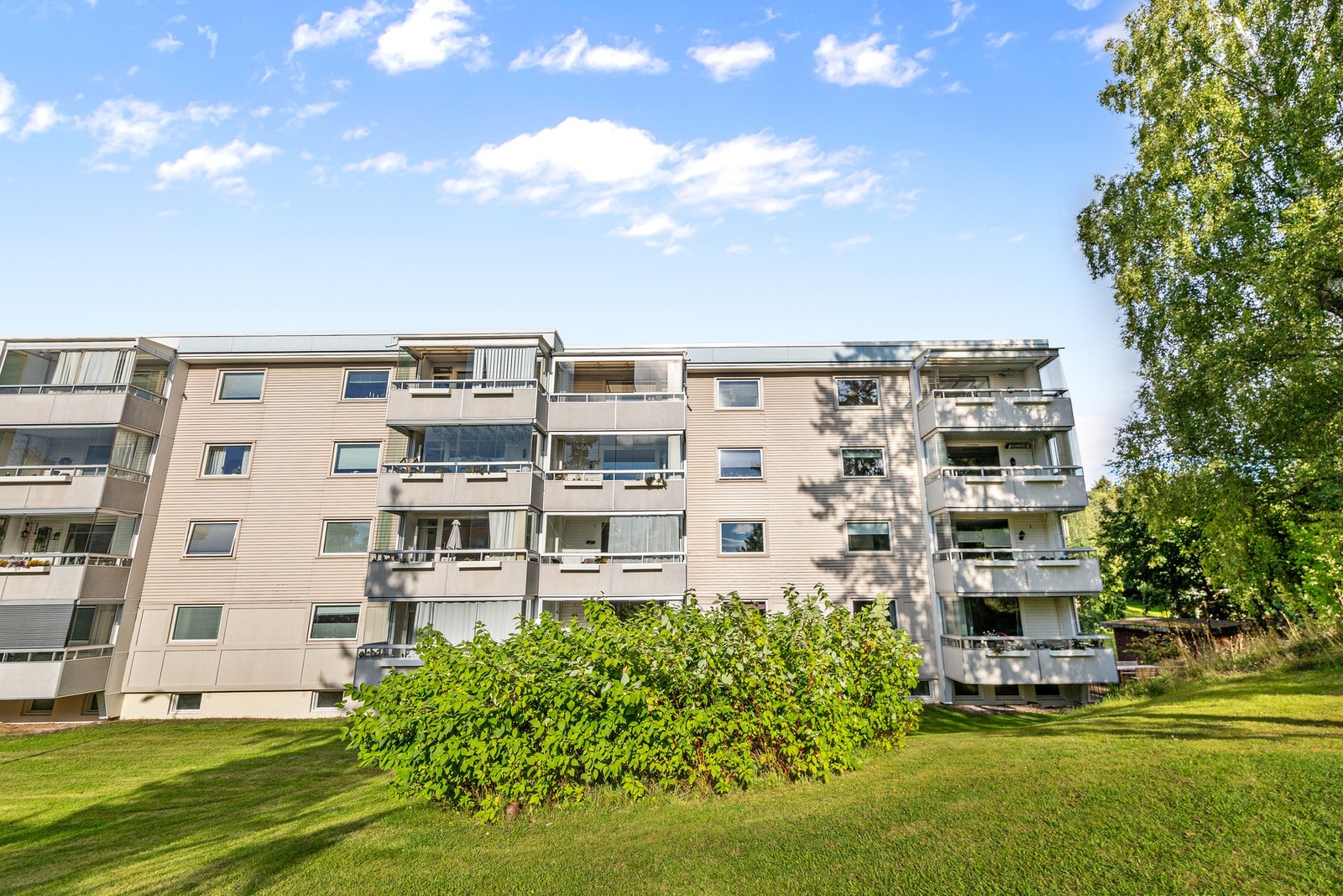 Velholdt boligblokk med pent opparbeidet fellesområde og grønne omgivelser Galleribilde