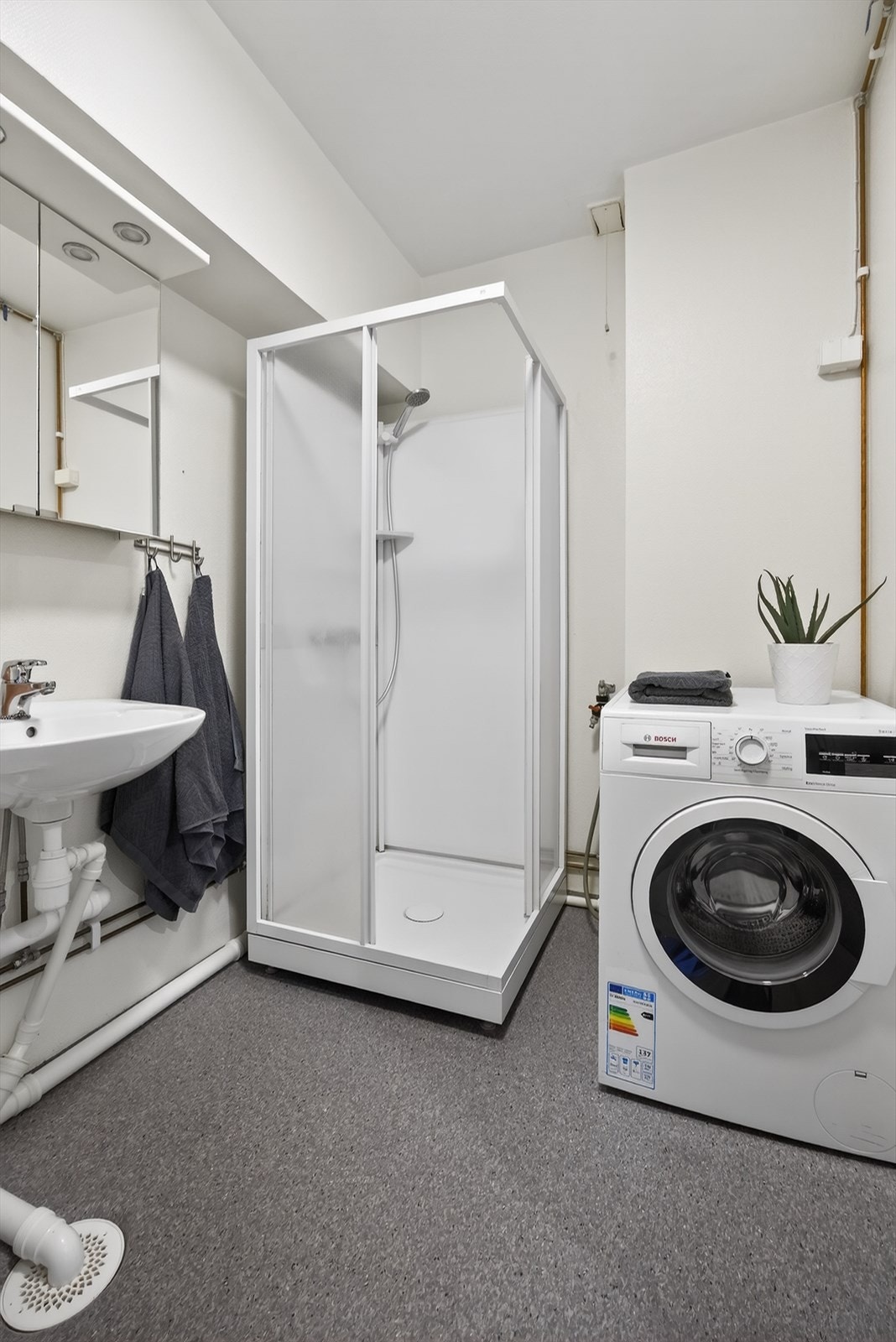 Badet er utstyrt med dusjkabinett og har opplegg for både vaskemaskin og tørketrommel. Galleribilde