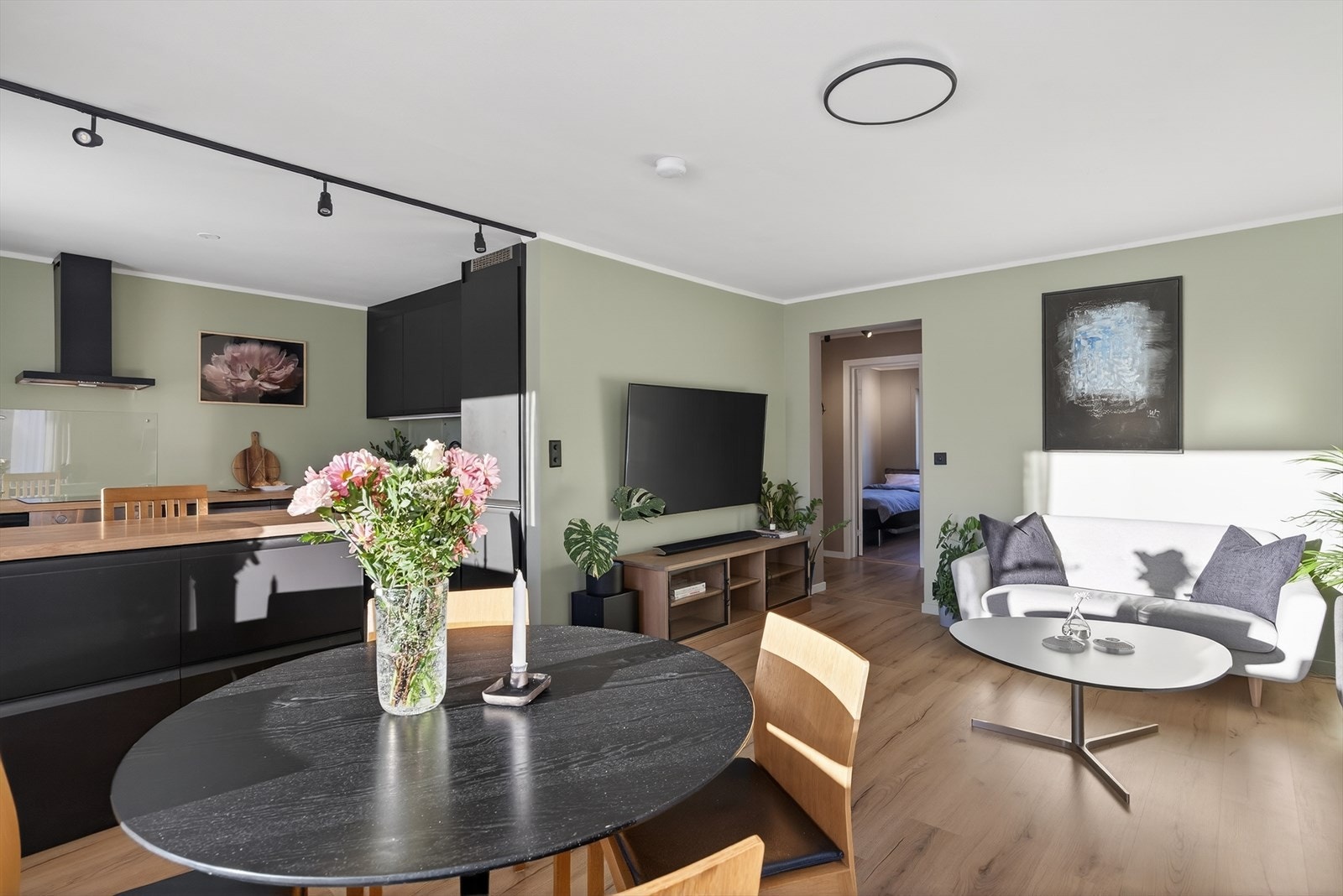 Detaljene gir boligen et gjennomført uttrykk, med pent gulv og sorte detaljer på brytere, stikkontakter, spotskinne og taklampe. Galleribilde