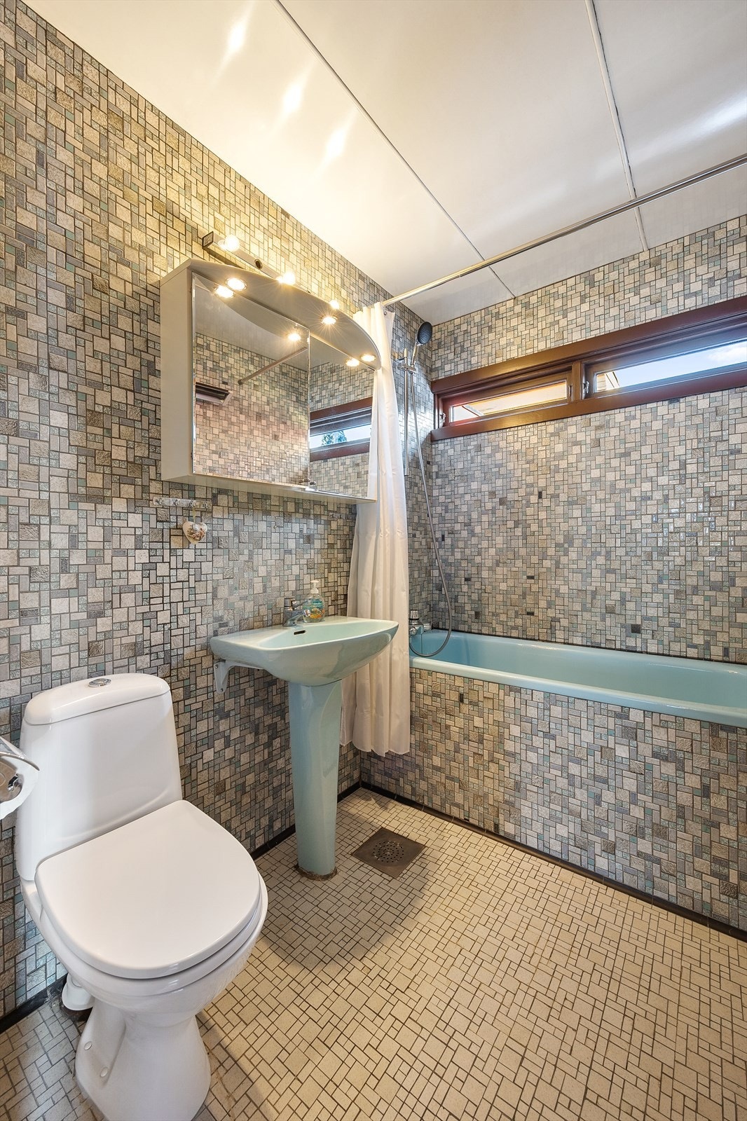 En veggmontert stråleovn sørger for varme på badet. Galleribilde