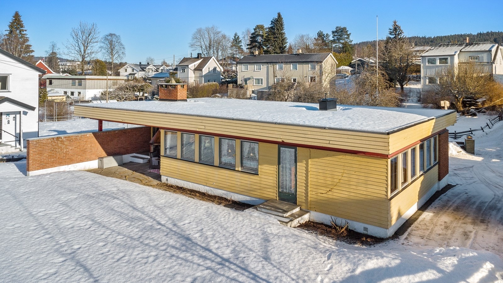 Huset ligger tilbaketrukket og skjermet fra veien. Galleribilde
