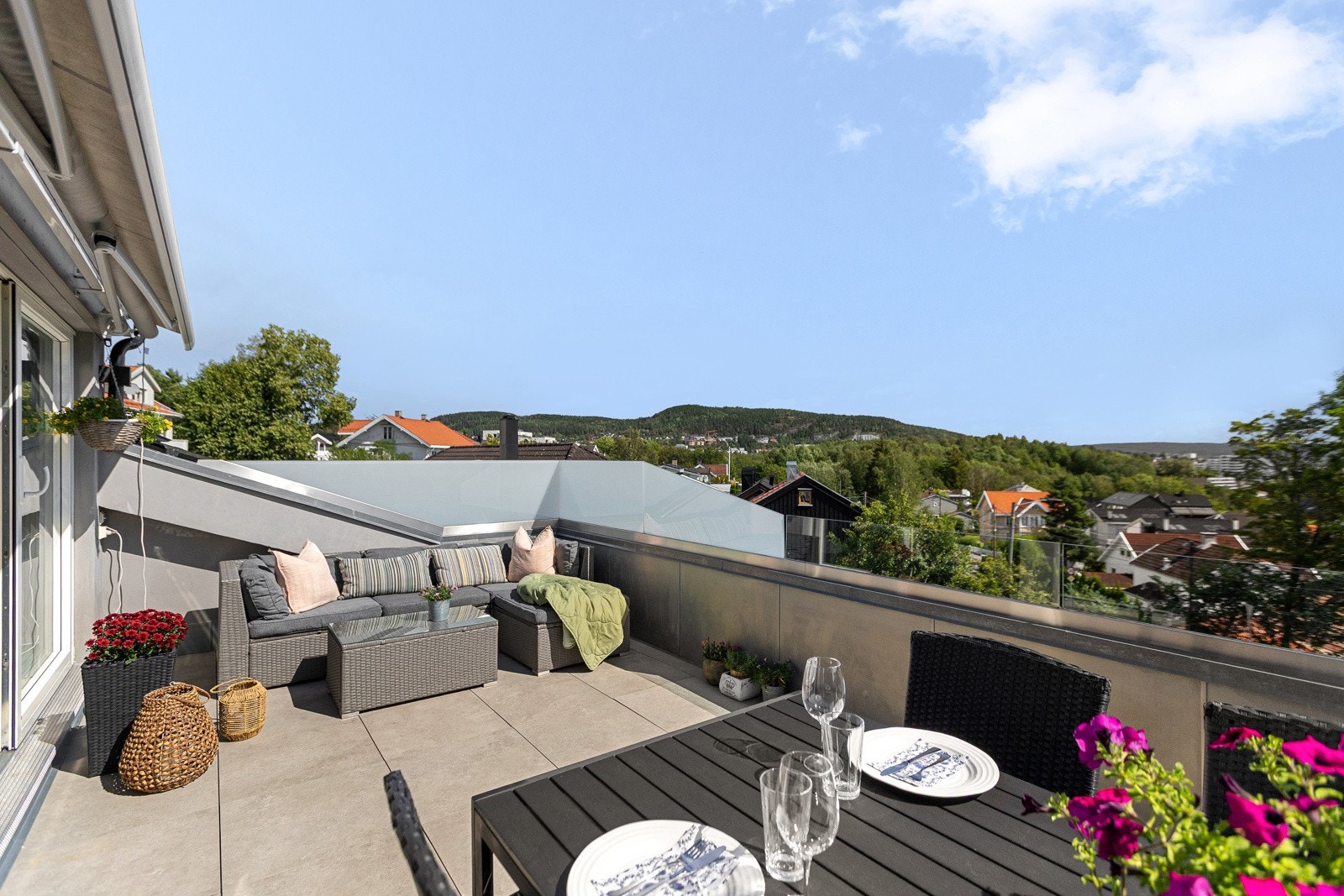 Takterrassen ligger utenfor kjøkkenet, og har flislagt dekke, tett rekkverk med glass øverst og en skjermende markise. Galleribilde