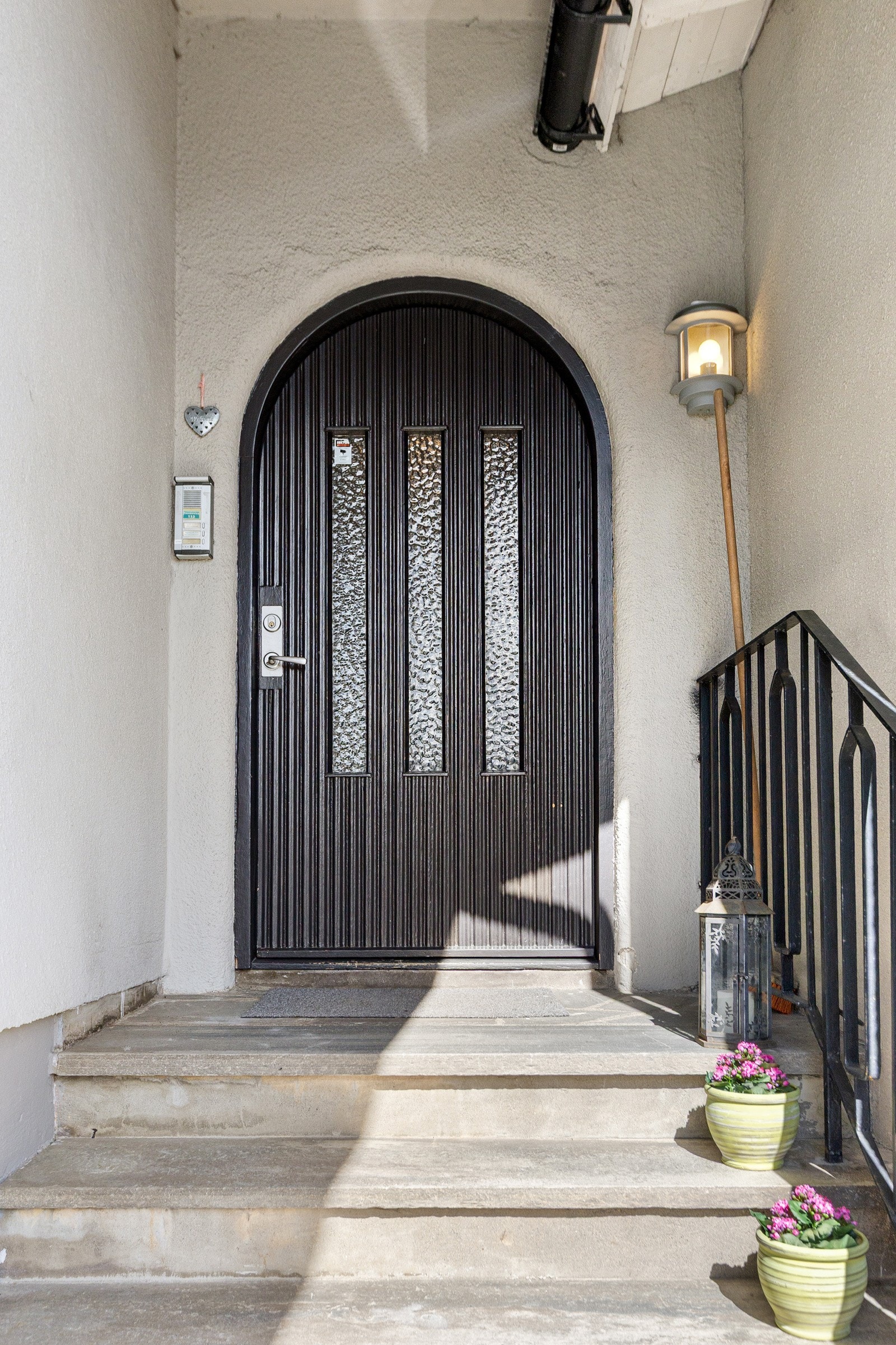 Boligen har felles inngang i første etasje, med adkomst via steinbelagt trapp og buet ytterdør. Galleribilde