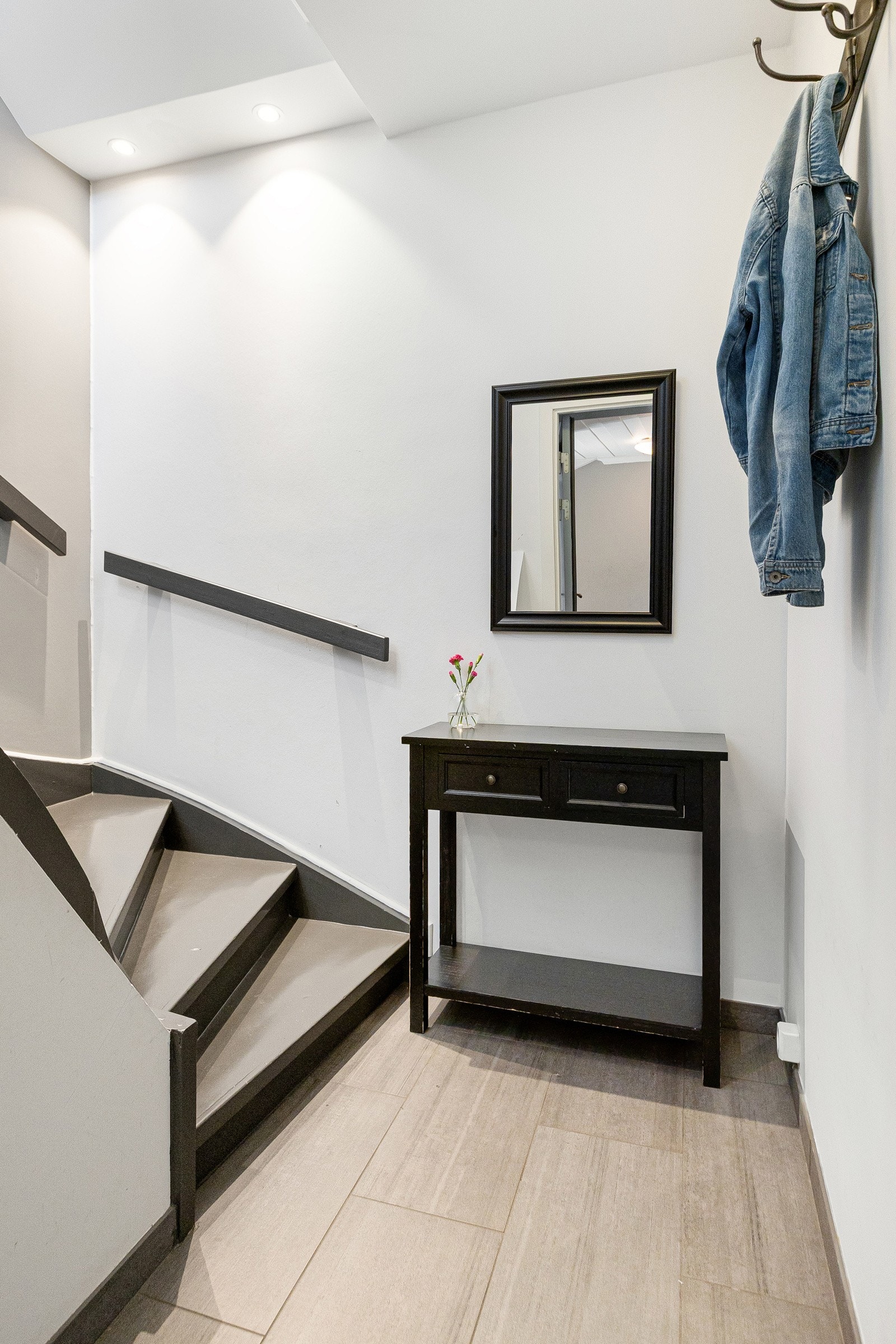 Boligen har privat inngang og entré i første etasje, med flislagt gulv og en trapp med mørke trinn. Galleribilde