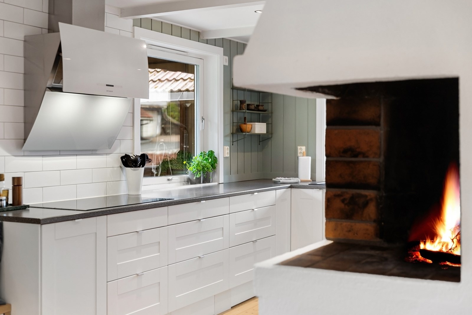 Kjøkkenet er utstyrt med integrerte hvitevarer, herunder platetopp, komfyr, kjøleskap og oppvaskmaskin Galleribilde