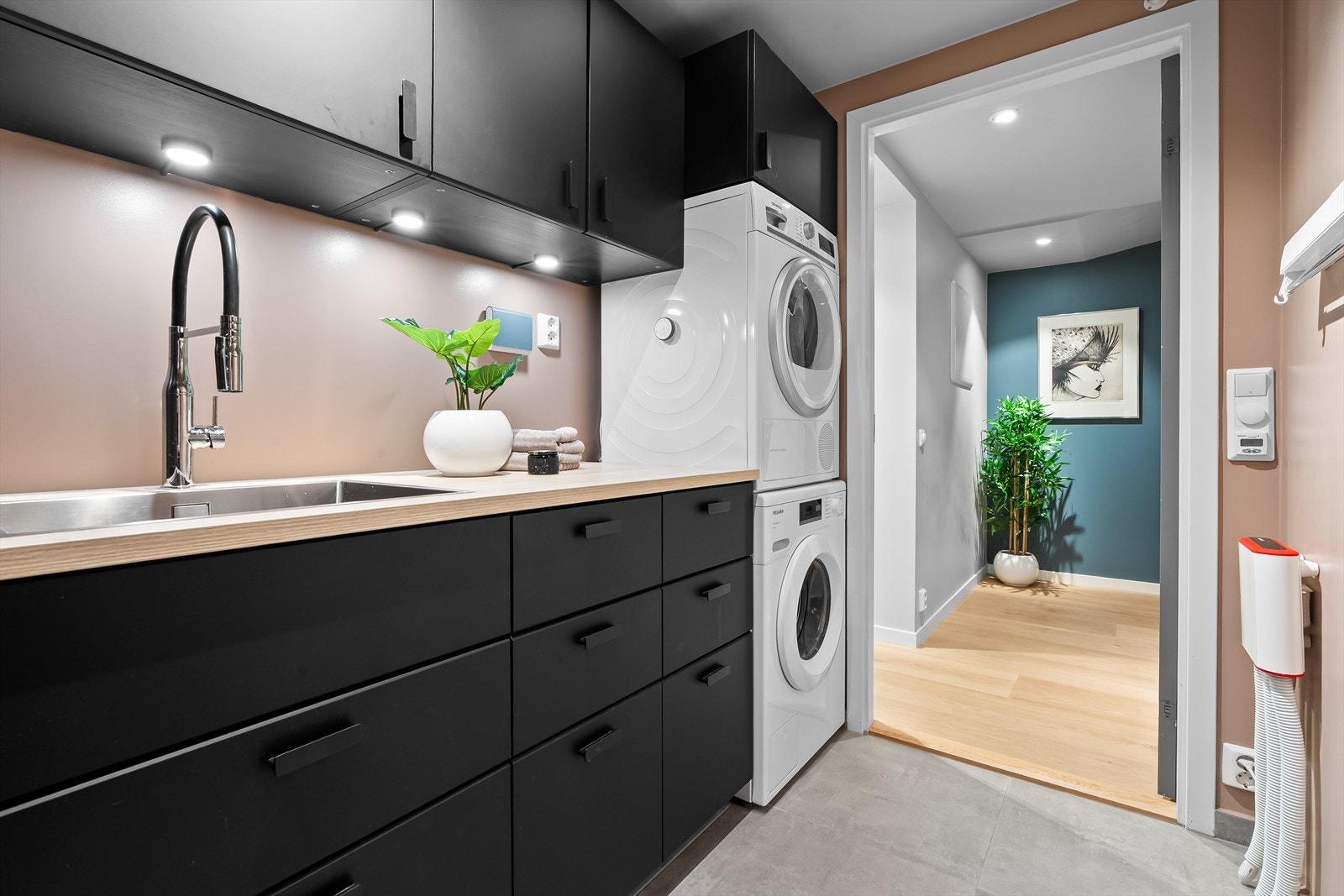 Rommet er innredet med vaskekum, opplegg for vaskemaskin, elektrisk styrt vifte og varmtvannstank. Galleribilde