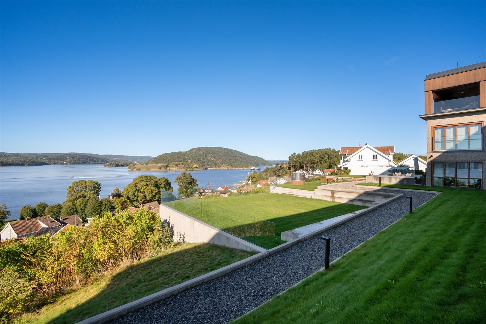 Fellesområdene er pent opparbeidet med diverse beplantninger, støttemurer, gangstier, plenarealer i flere nivåer og har asfaltert adkomst. Det er også felles takterrasse med sittegruppe og felles garasjeanlegg. Galleribilde