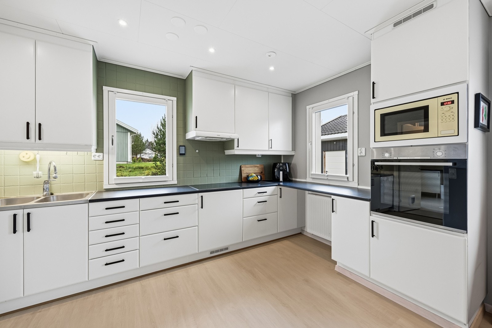 Pent, klassisk kjøkken i åpen løsning, nytt i 2012. Innredningen består av hvite, slette fronter med foring opp til tak, og mørk laminert benkeplate med nedfelt vaskekum i rustfritt stål. Galleribilde