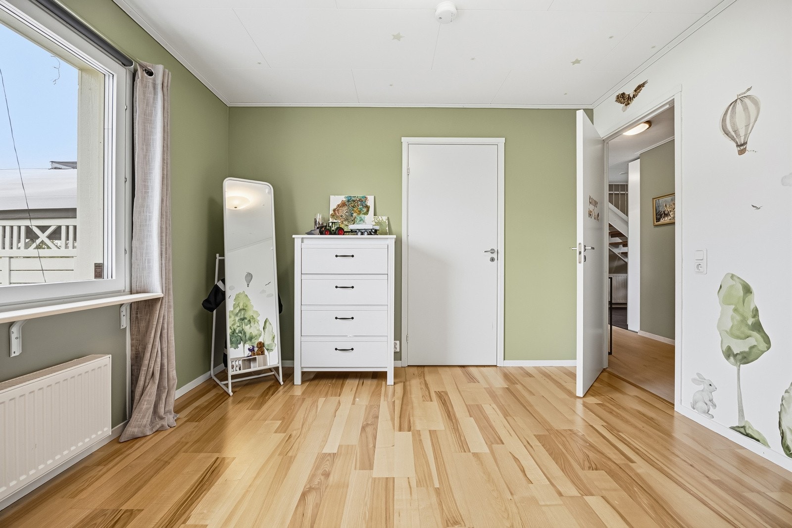 Rommet har malte veggflater, laminat på gulv og store vindusflater. Oppvarming via vannbåren varme tilknyttet radiator. Galleribilde