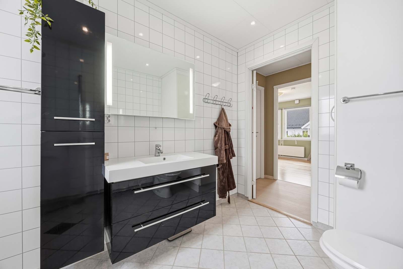 Bad nr. 2 i 1. etasje har fått tilstandsgrad 3 og anses å ha behov for totalrenovering. Badet har fliser på gulv, baderomsplater på vegg og er innredet med servantmøblement, høyskap, speil med integrert belysning og toalett. Galleribilde