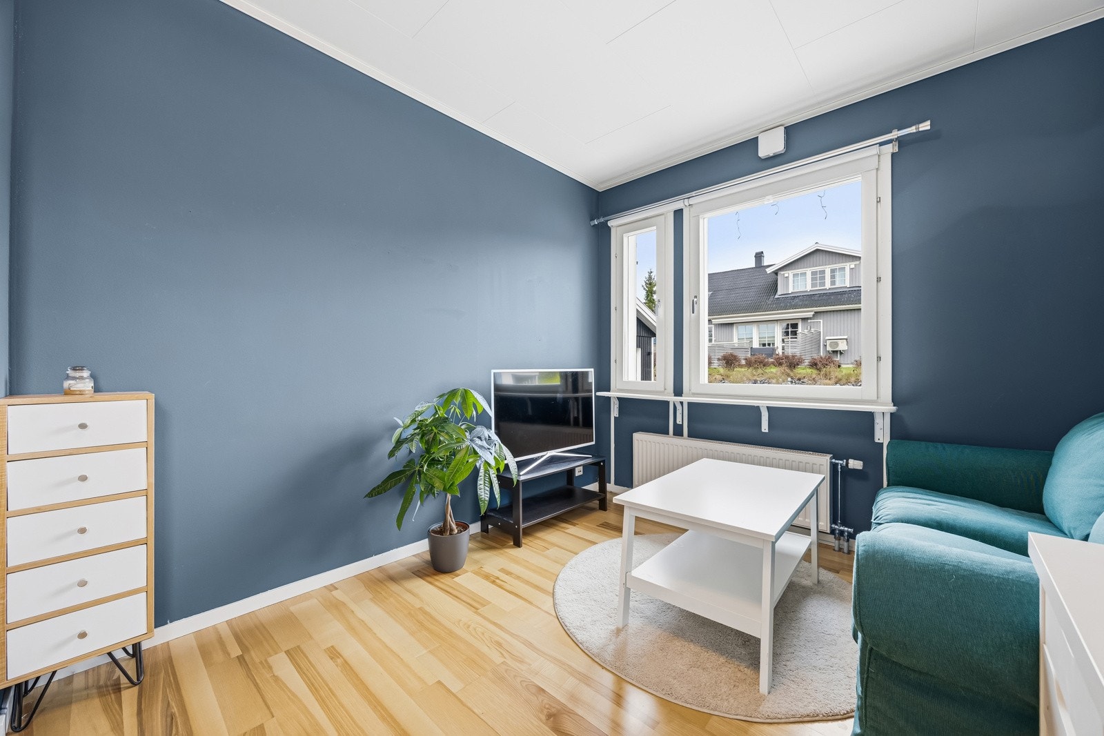 Rommet har malte veggflater, laminat på gulv og store vindusflater. Oppvarming via vannbåren varme tilknyttet radiator. Galleribilde