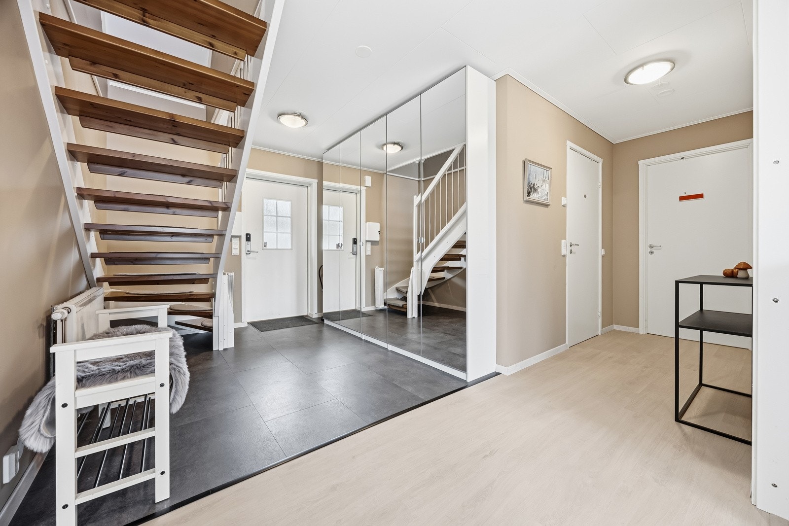 Lys og innbydende entré/hall med storformatfliser på gulv og lyse, malte veggflater som gir et godt førsteinntrykk av boligen. Det er montert rikelig med garderobeskap som gir god plass til oppbevaring av yttertøy og sko. Galleribilde