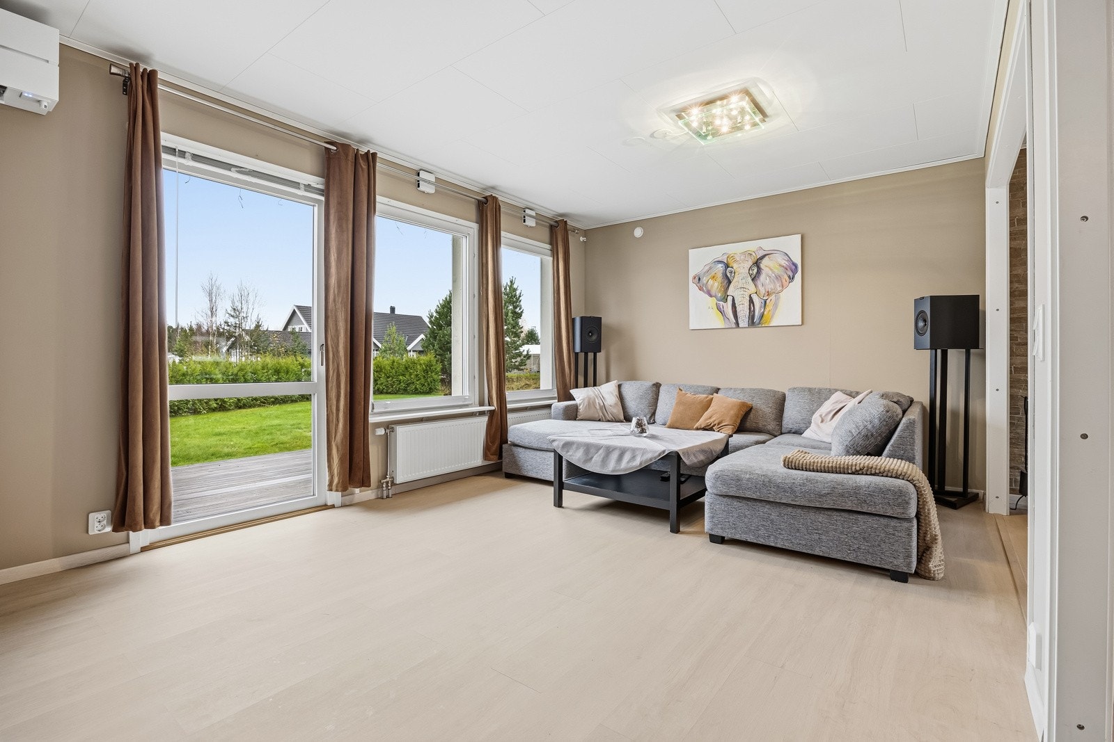 Den åpne stuen fremstår som meget innbydende med delikate og tidsriktige farger. Gode vindusflater i flere himmelretninger slipper inn rikelig med lys og gir rommet en behagelig atmosfære. Galleribilde