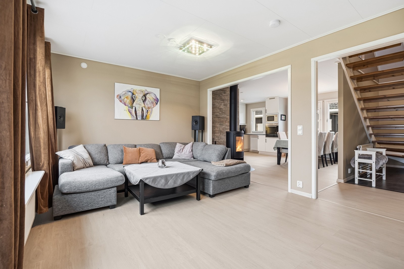 Gulvflater er belagt med lyspigmentert laminat (ny i 2025) som strekker seg sømløst inn mot kjøkken og gang. Galleribilde