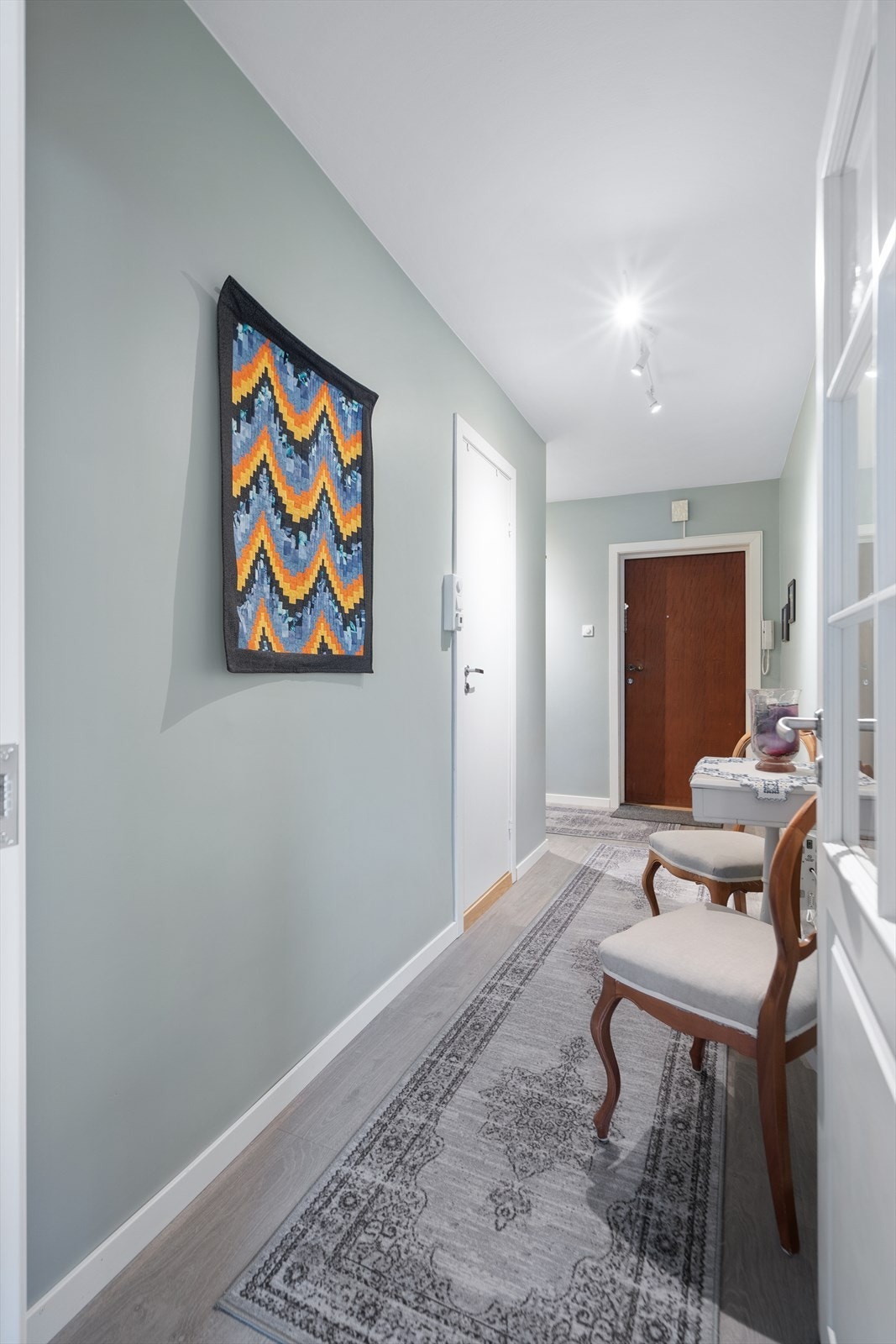 Fra gangen er det adkomst til flere av leilighetens rom - helheten oppleves lun og gjennomført med dempede farger og lyse gulv Galleribilde