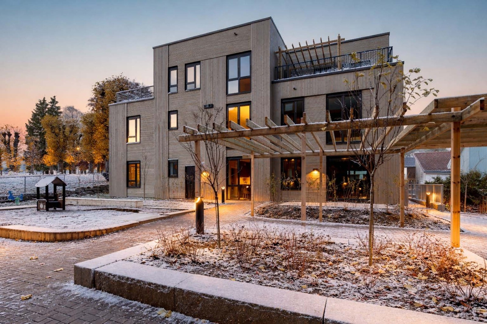 Mellom byggene ligger en trivelig, opparbeidet felles bakgård med sittegrupper, beplantning og lekeapparater. Galleribilde