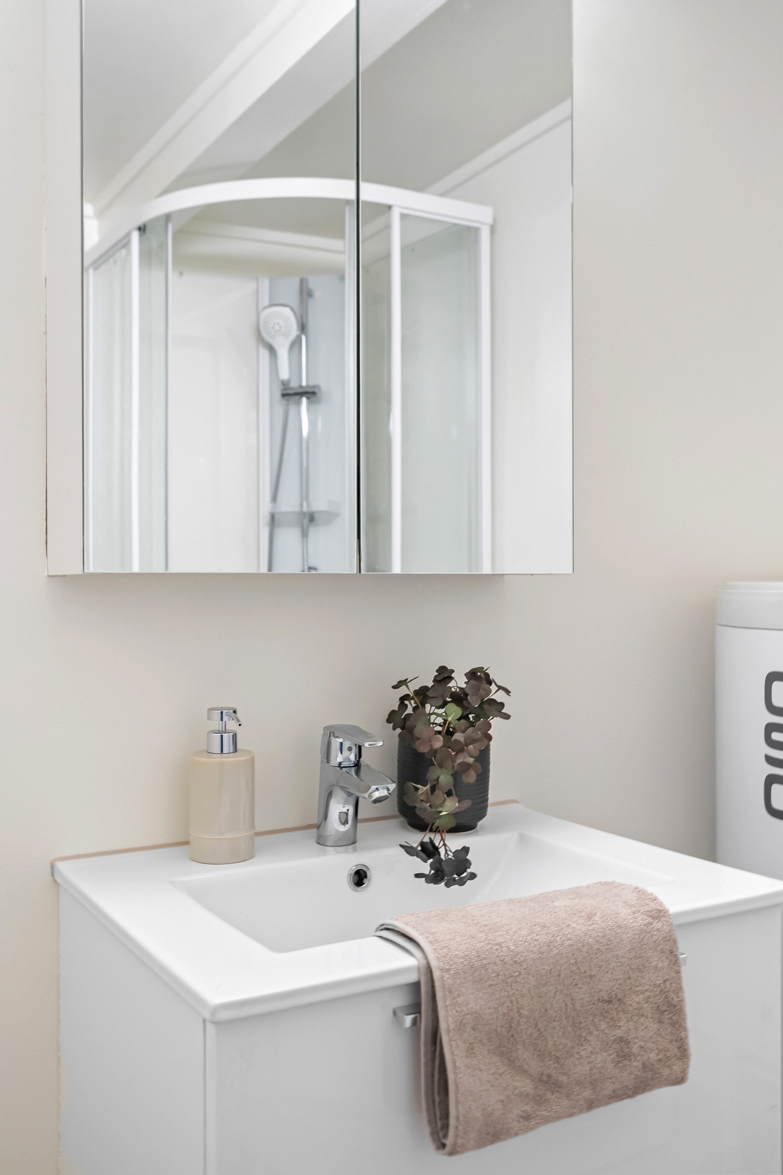 Badet er utstyrt med dusjkabinett, servantinnredning, gulvstående toalett og opplegg for vaskemaskin Galleribilde