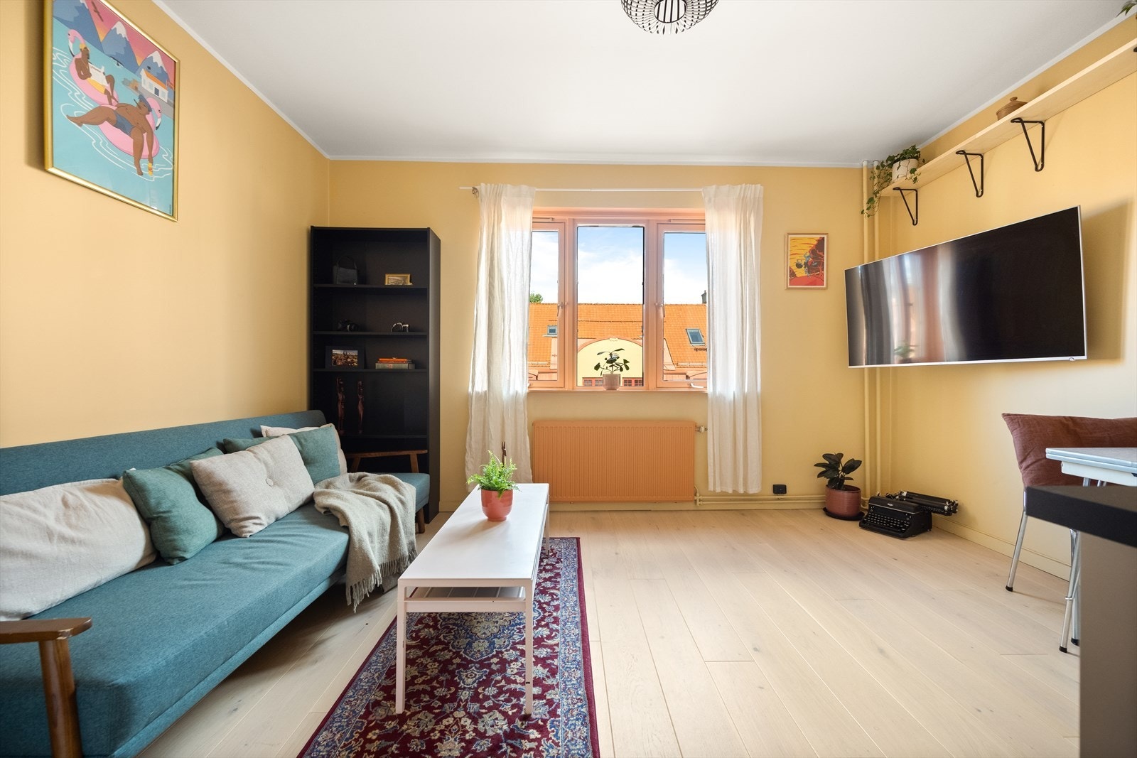 En arealeffektiv planløsning med plass til sofa, seng, spisebord og øvrig møblement Galleribilde