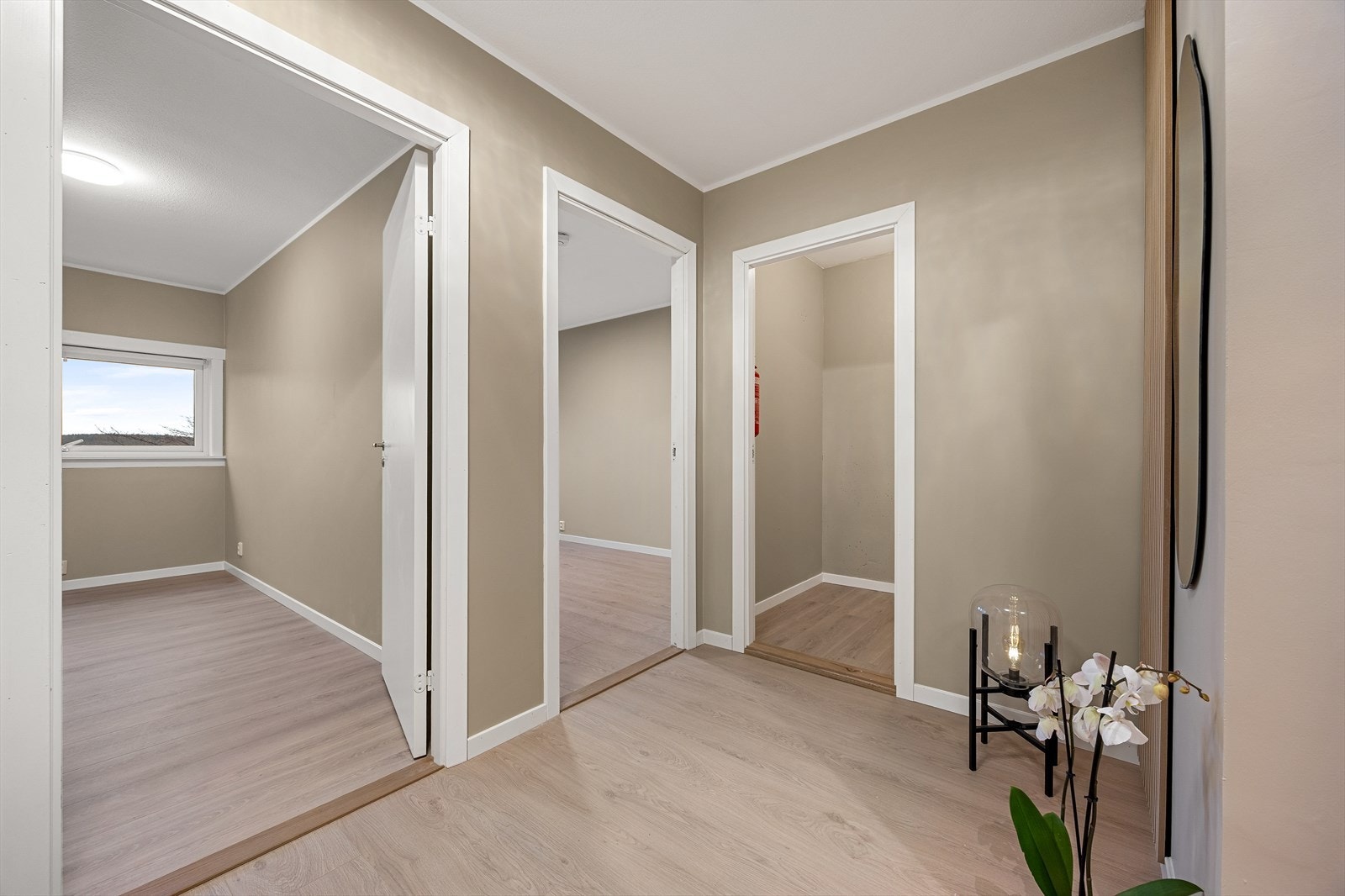 En mellomgang leder videre til leilighetens tre soverom og en innvendig bod. Galleribilde